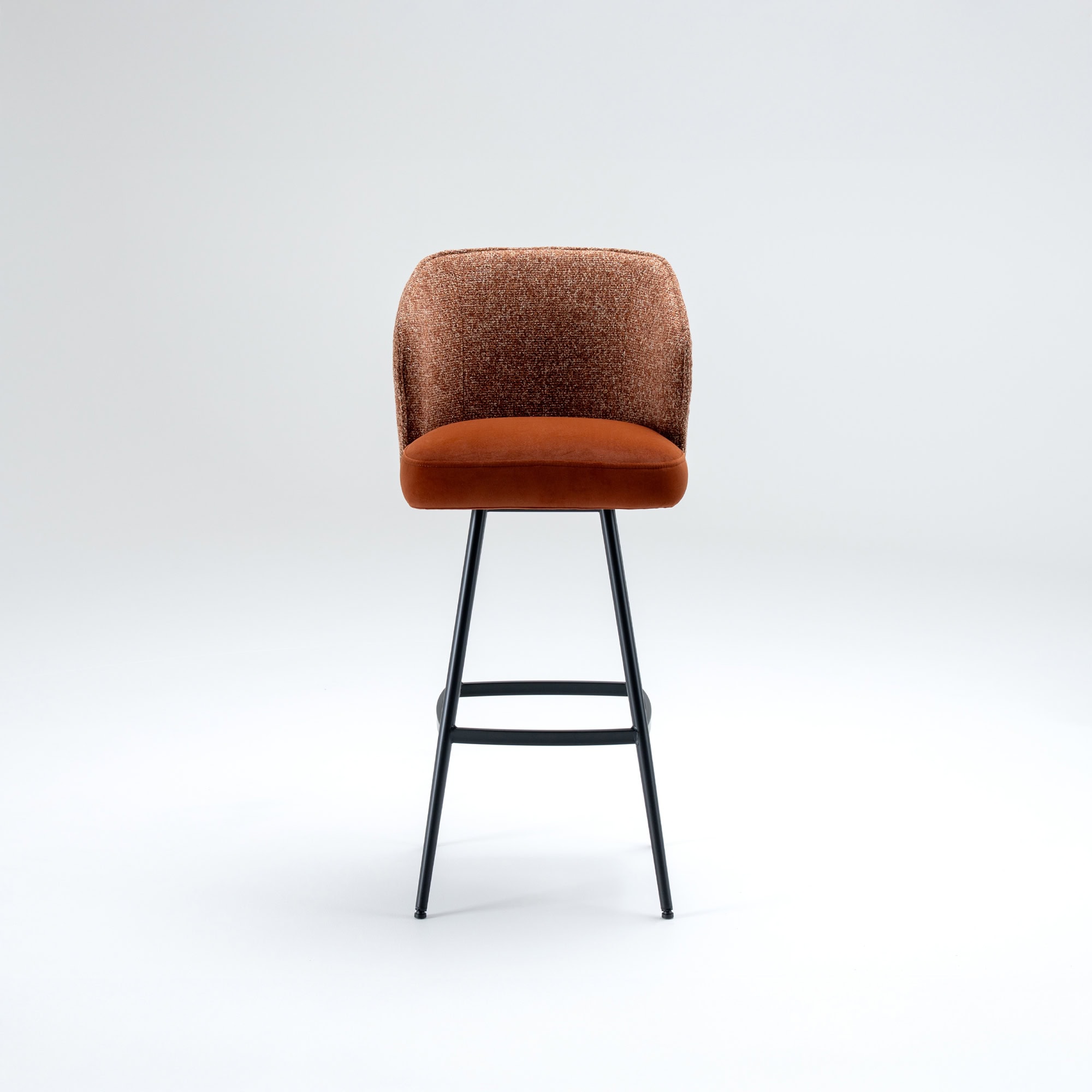 Front view of a modern bar stool with a textured burnt orange backrest, a plush orange seat, and slender black metal legs, set against a light grey background.