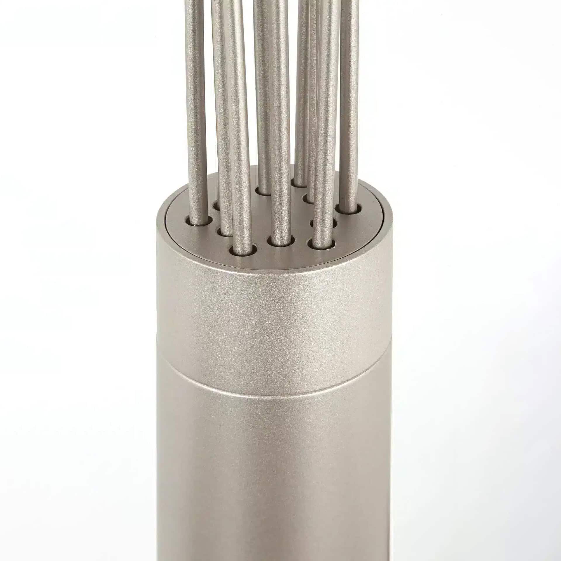 Close-up of a brushed silver-grey cylindrical object with multiple thin, vertical metallic rods emerging from its top surface, set against a white background.