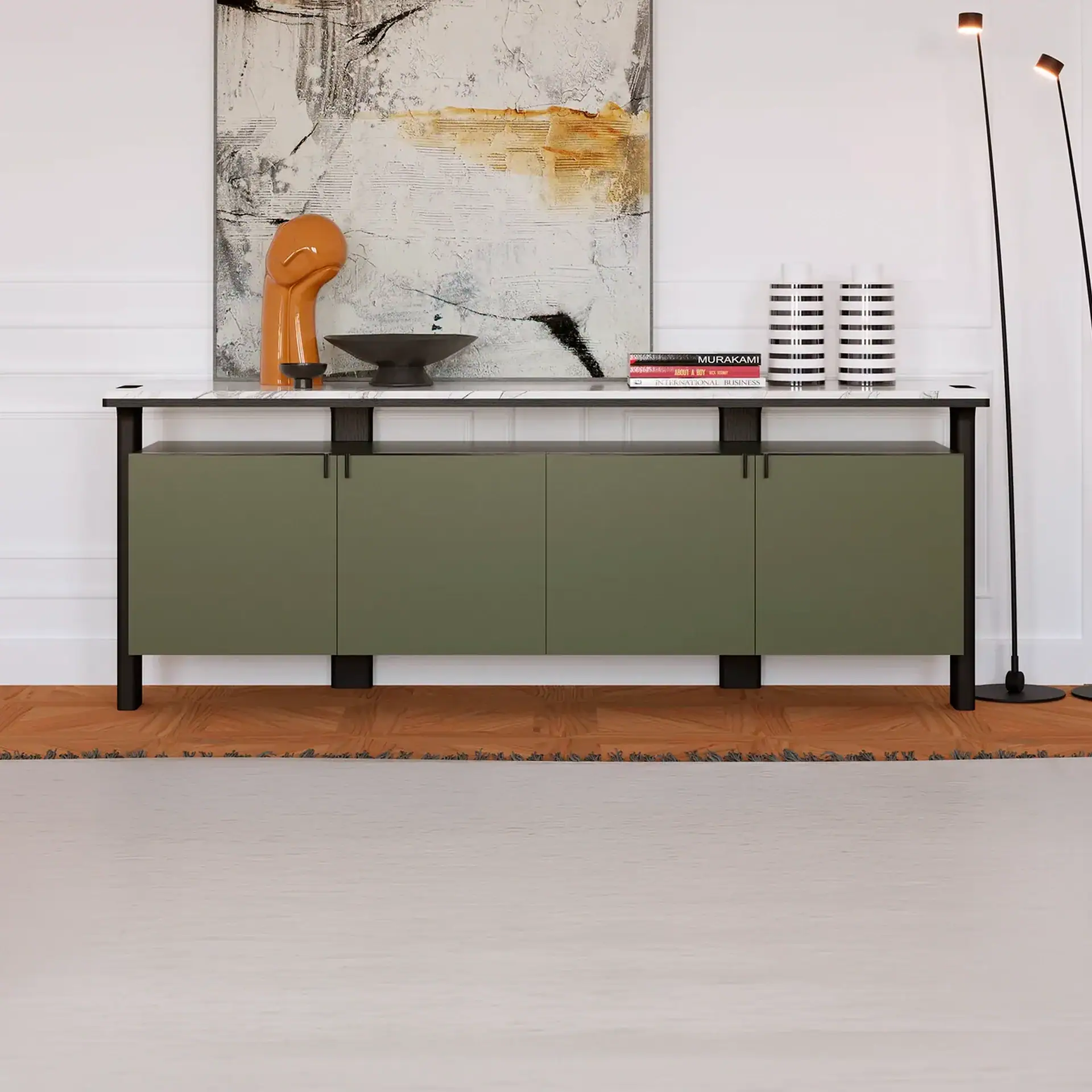 A modern olive-green sideboard with a marble top, decorated with an abstract painting, an orange sculpture, books, and striped vases, in a room with a white wall and wooden floor.