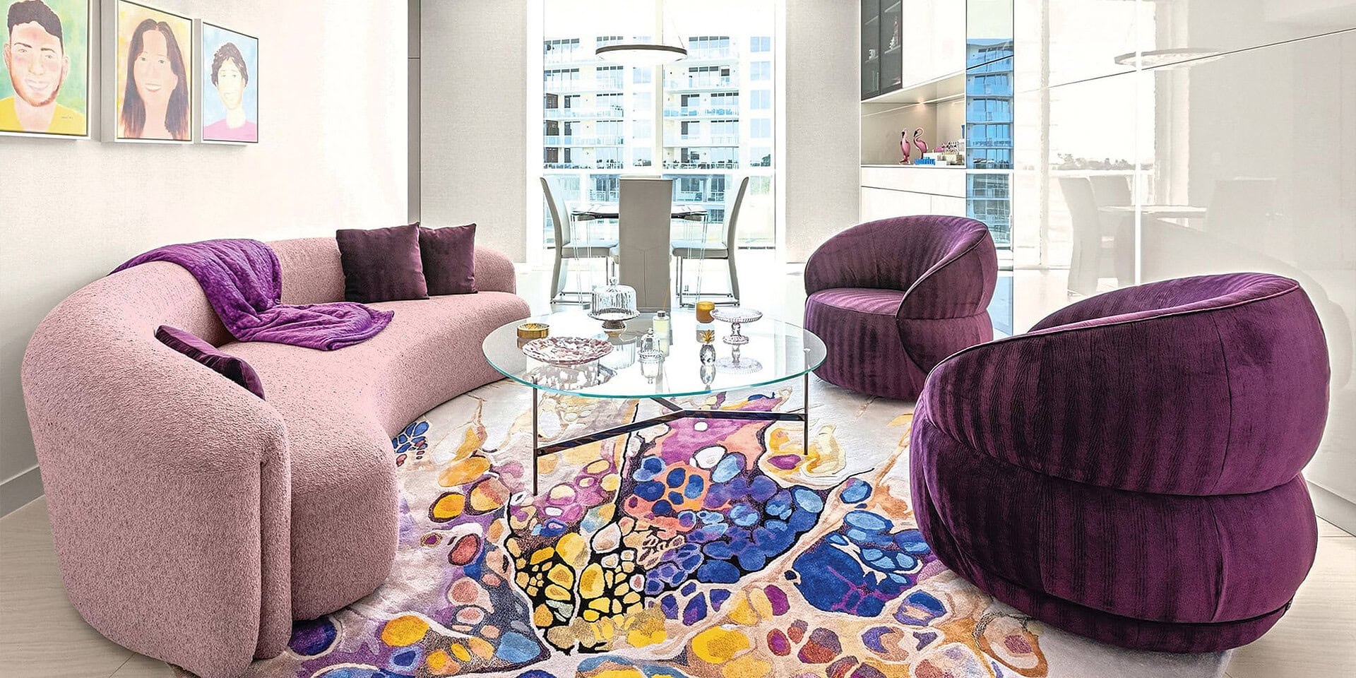 Elegant contemporary living room featuring plush purple and pink seating with a vibrant, patterned a.