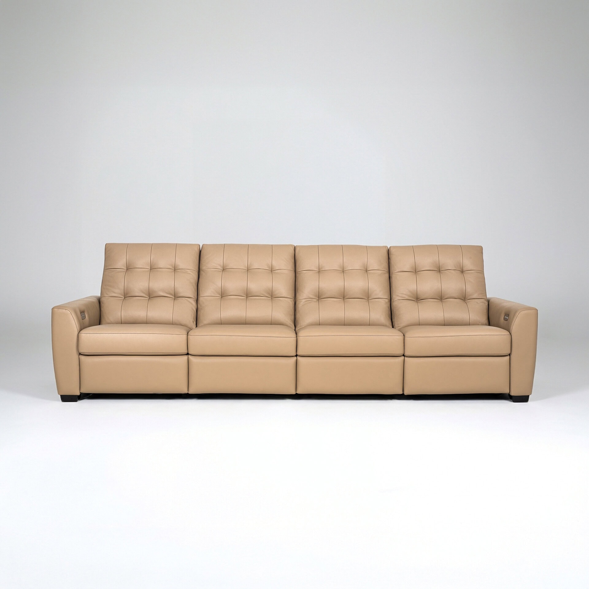 Modern beige sofa with tufted cushions and armrests.