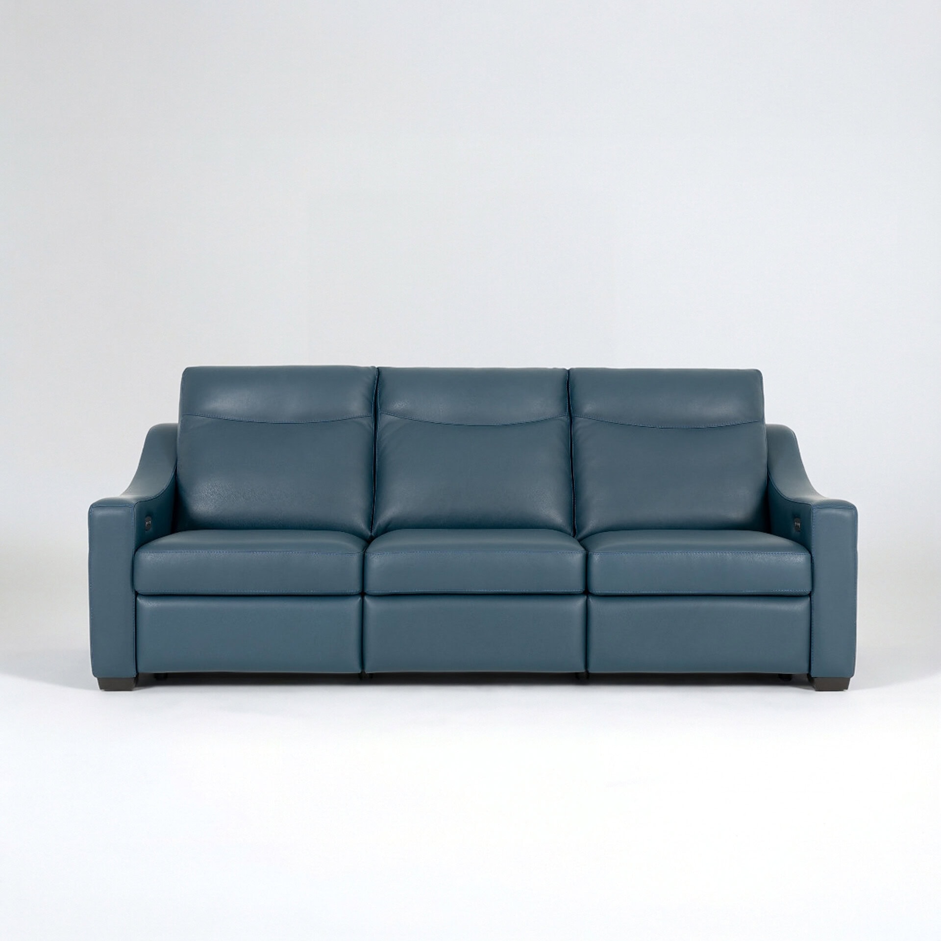 Modern blue leather sofa with plush cushions and armrests.