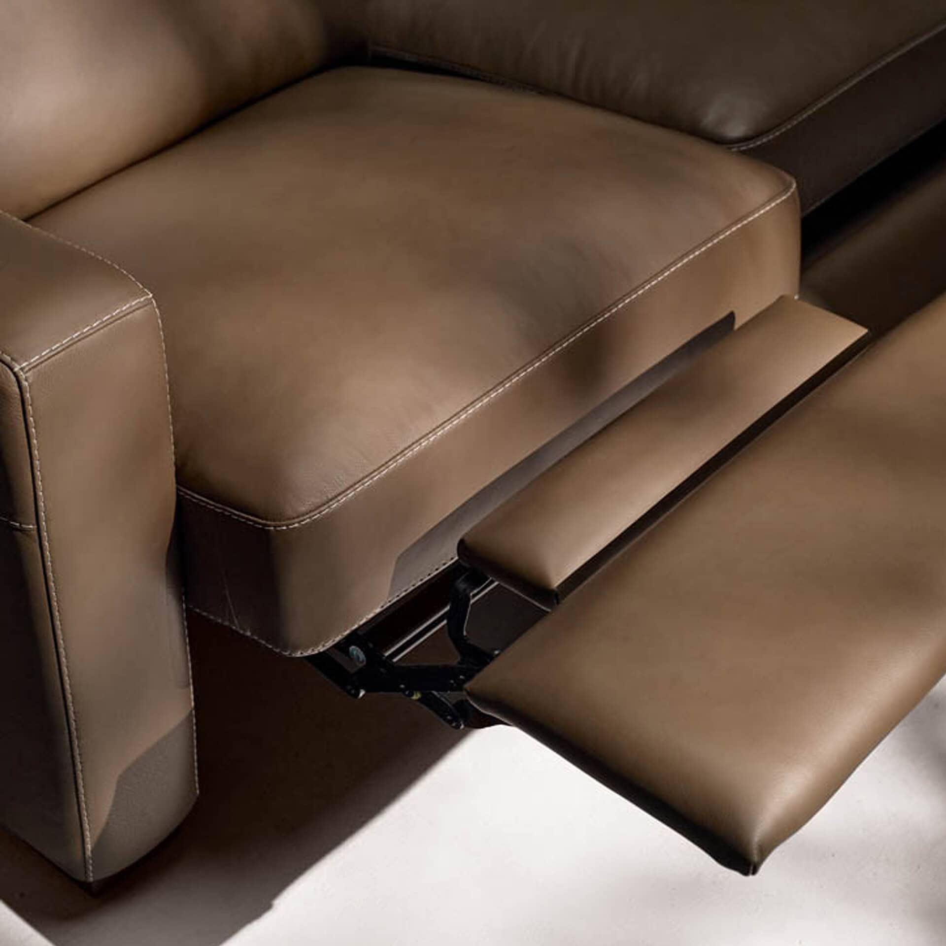 Brown leather sofa with adjustable footrest for enhanced comfort and modern design.