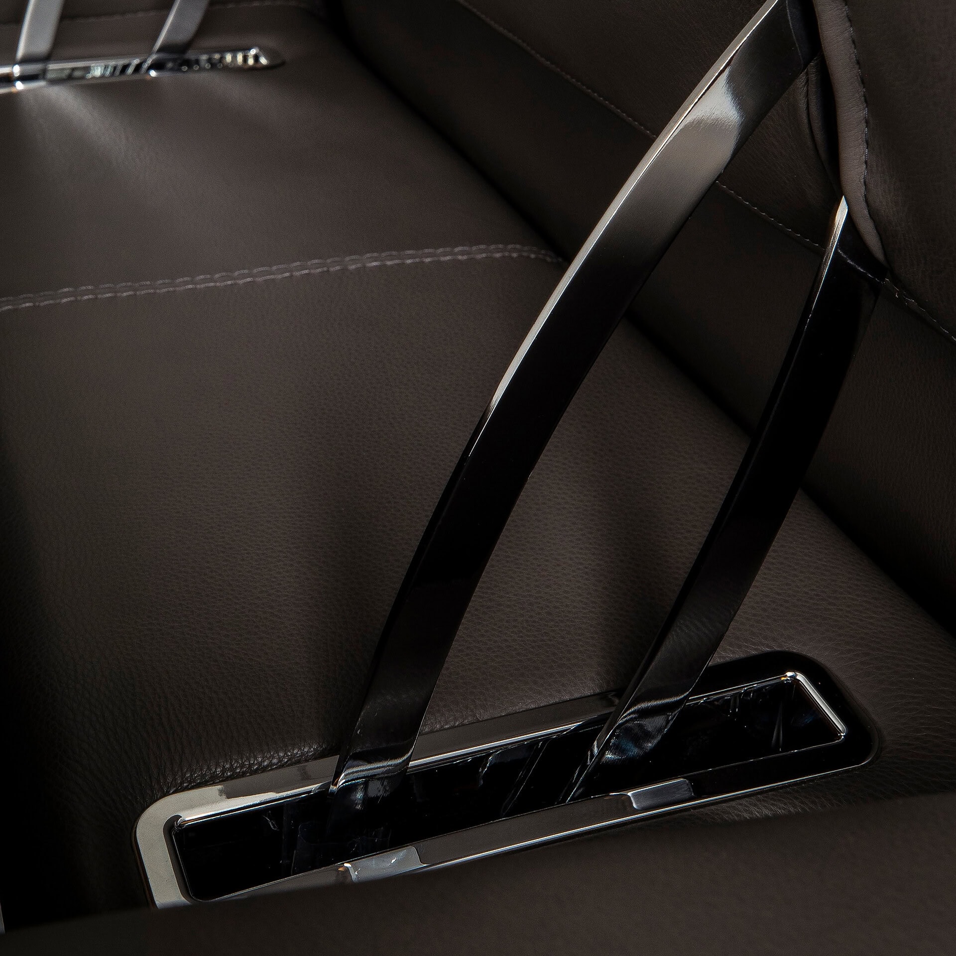 Modern leather sofa with sleek metal armrest for stylish living room seating.