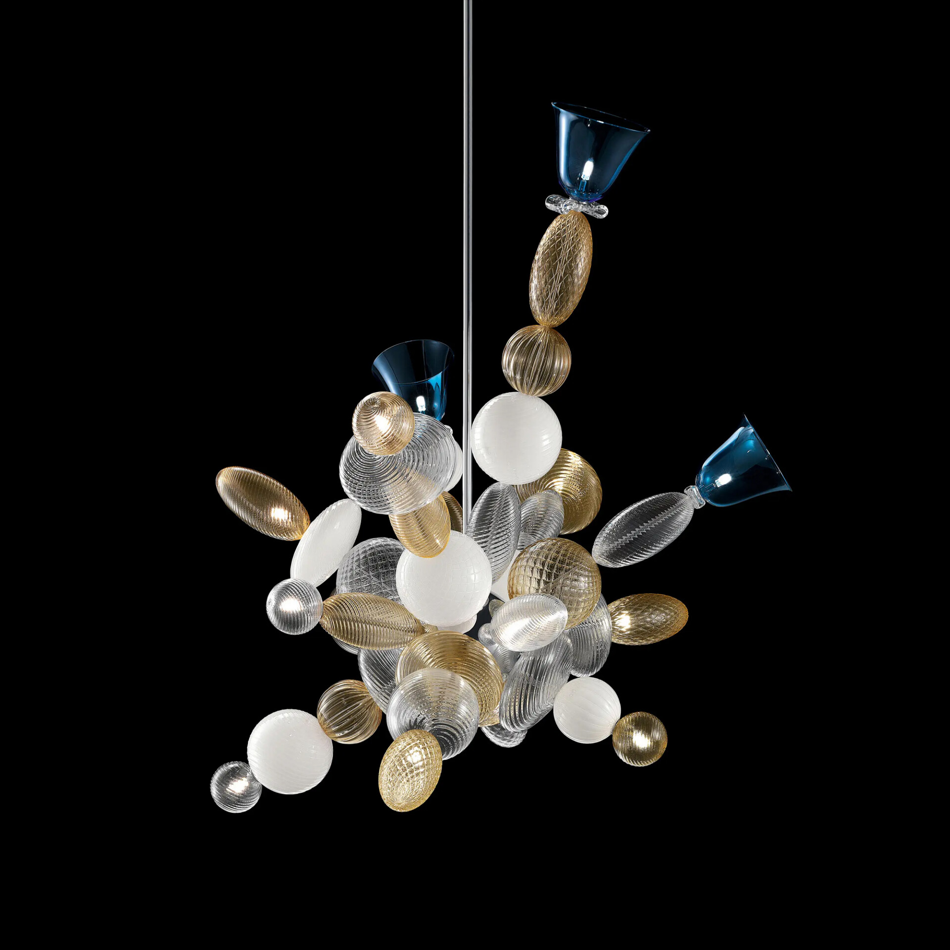 A modern chandelier with clear, amber, white, and blue textured glass spheres and ovoids clustered together, hanging from a silver rod against a black background.