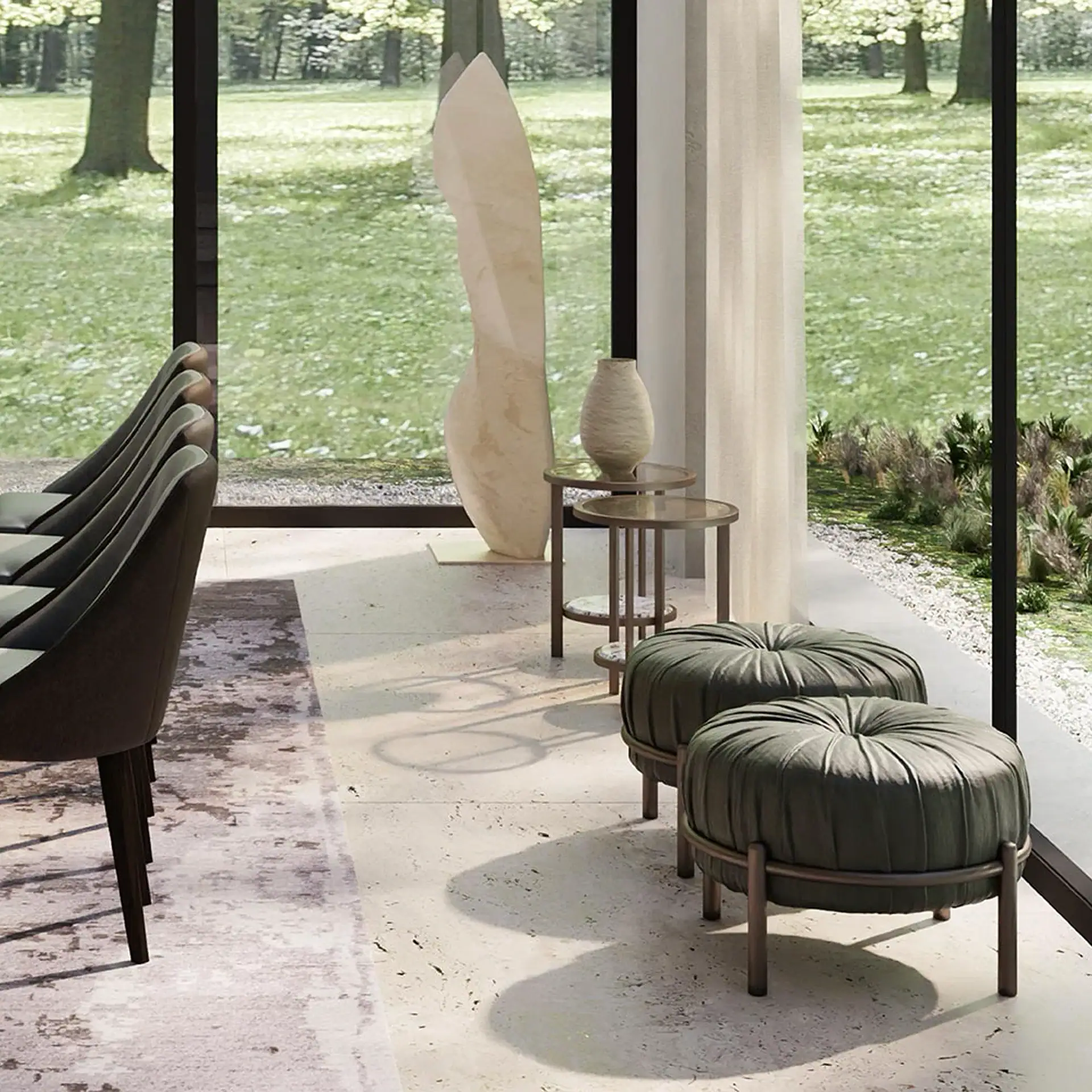 A modern room with large windows overlooking a green landscape, featuring dark chairs, a light sculpture, tiered side tables, and two dark green ottomans.