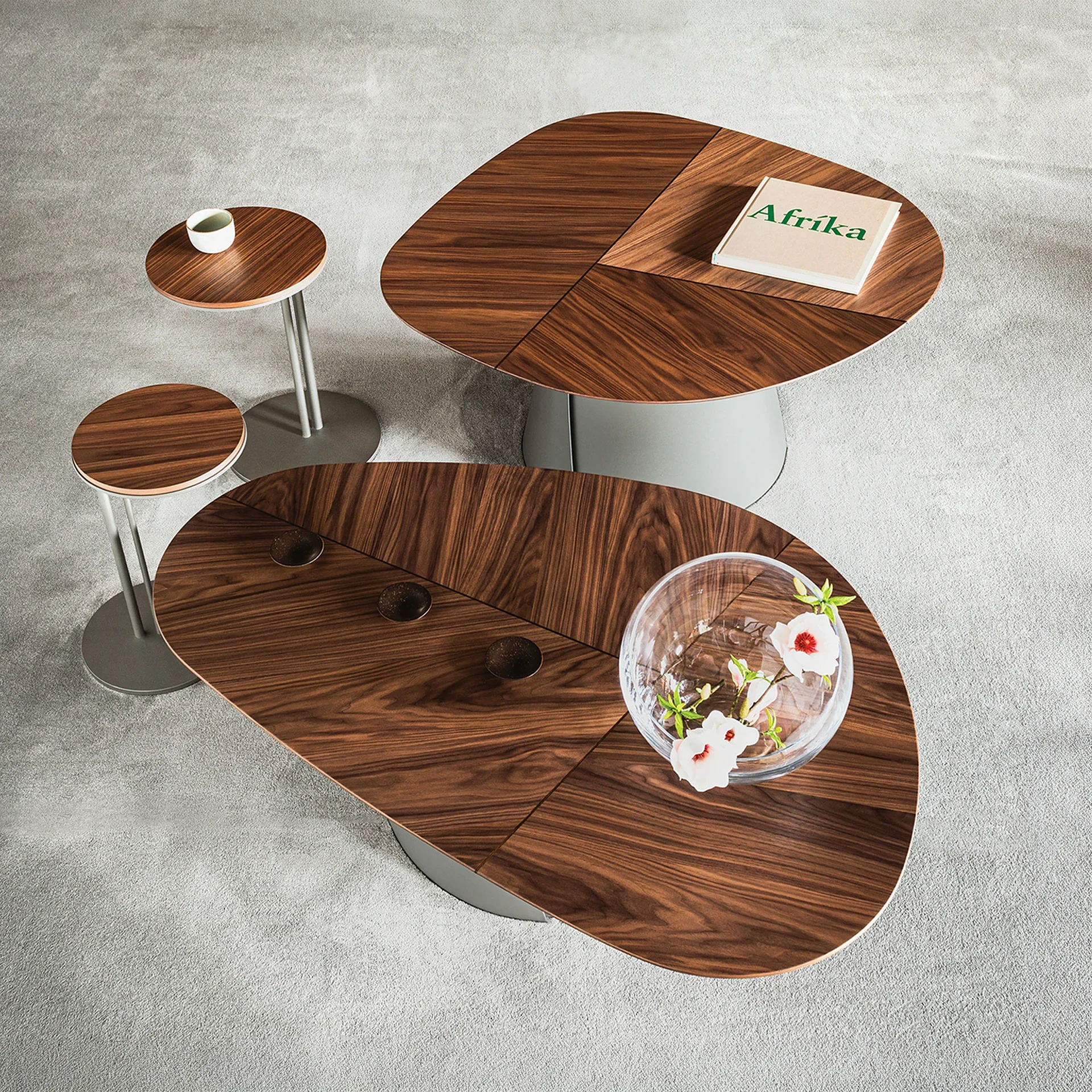 Sklar Furnishings round coffee tables with wood veneer tops and metal bases in a modern living space.