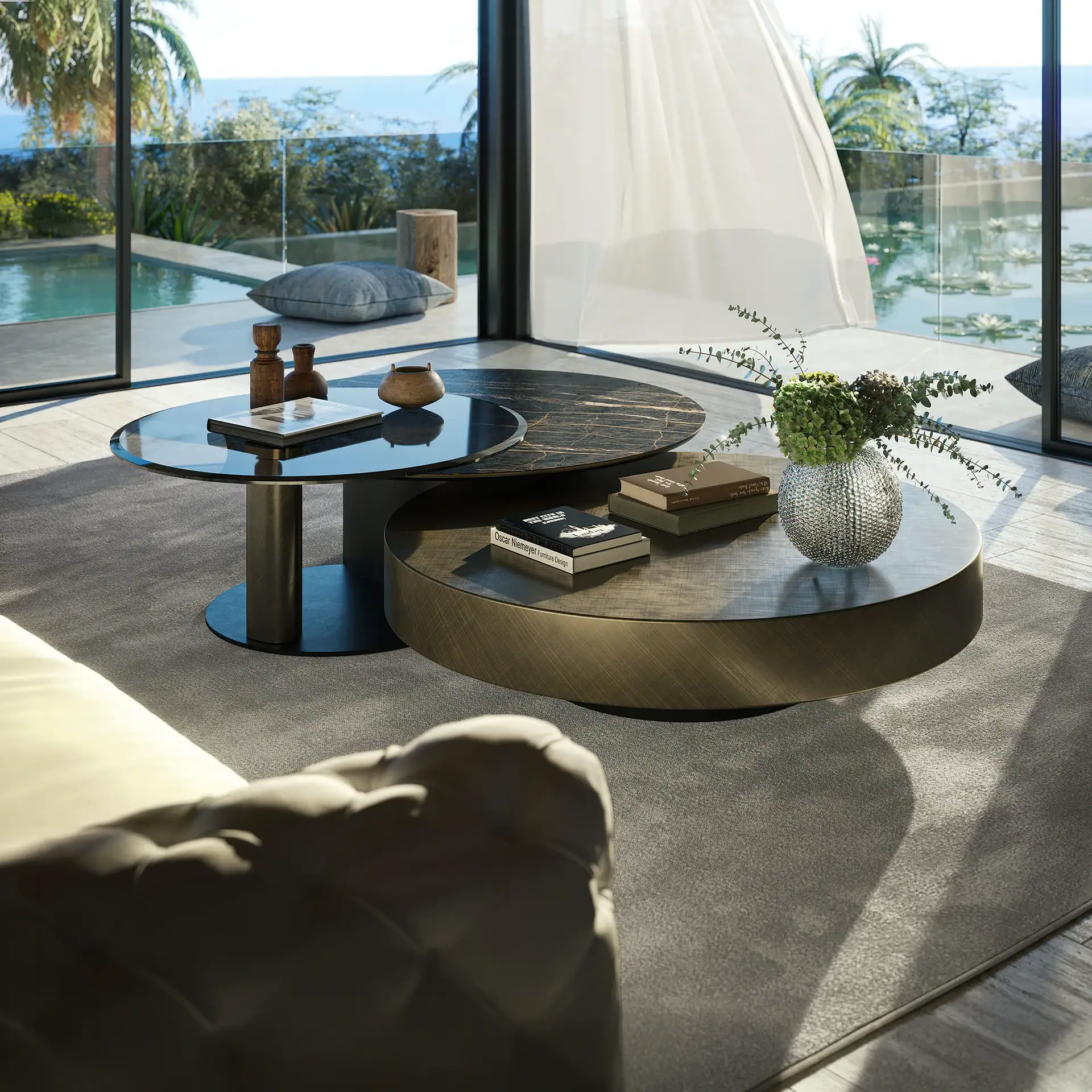 A modern living room with nested coffee tables, a sofa, and a large window overlooking a pool, pond with water lilies, palm trees, and the ocean.