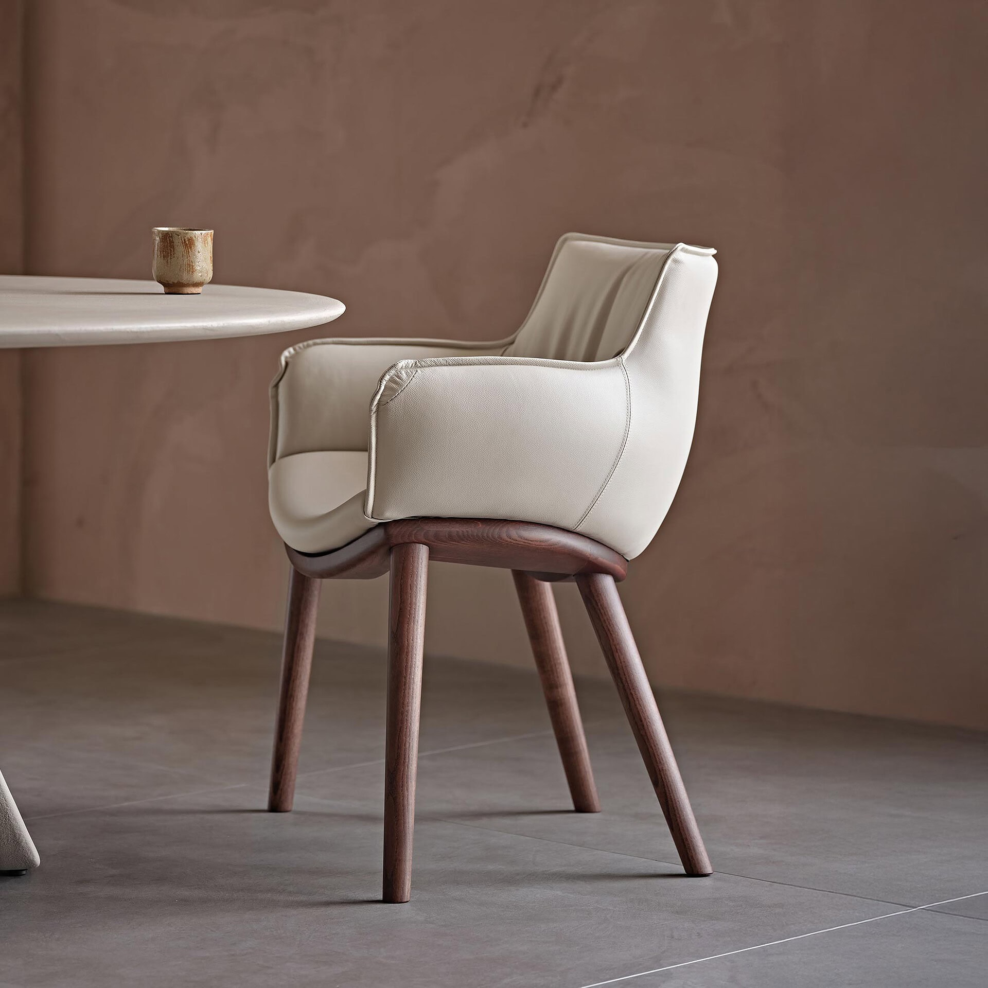 Elegant modern upholstered dining chair with wooden legs.