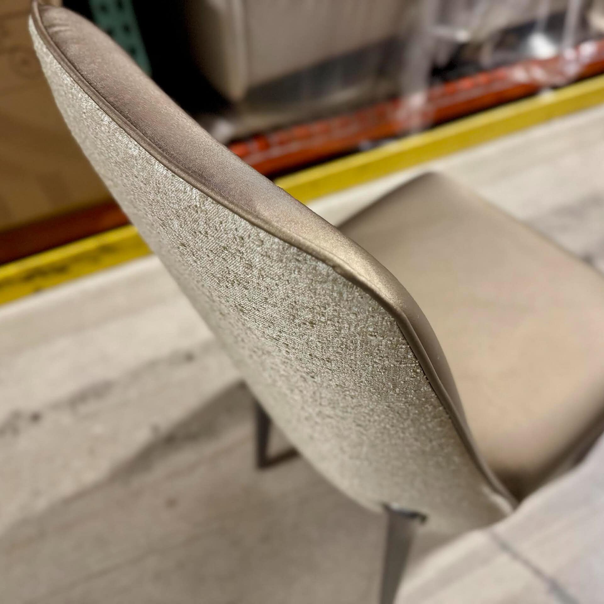 Modern beige upholstered dining chair with sleek design.