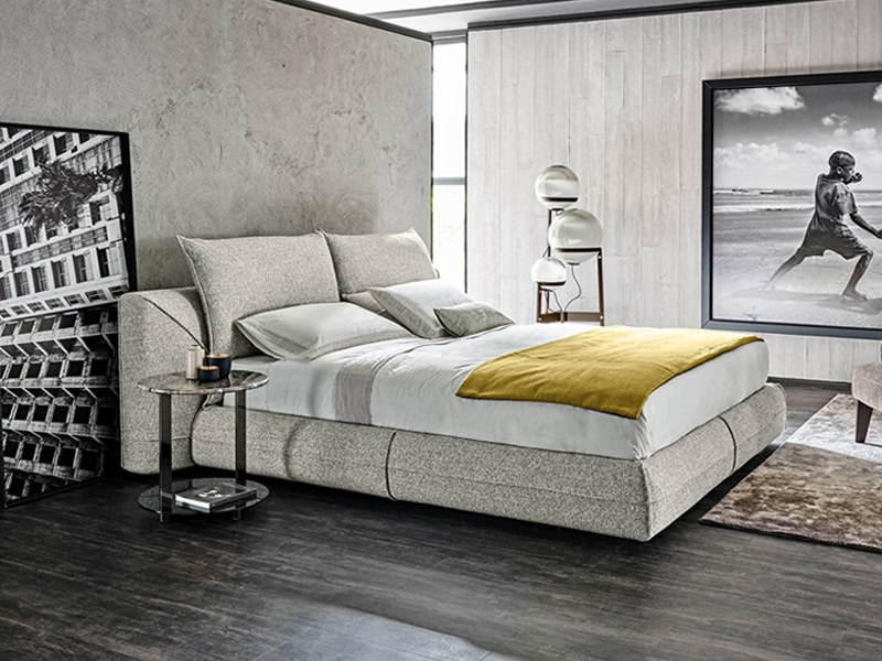 Modern upholstered bed with neutral tones and contemporary decor.