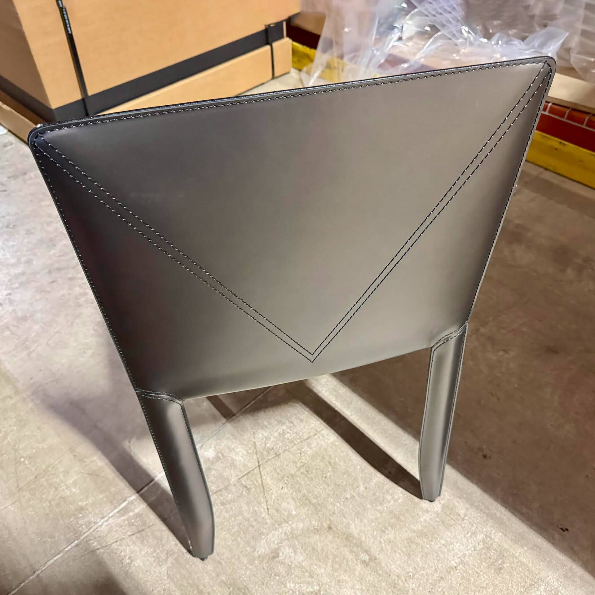 Elegant gray upholstered dining chair with sleek design and sturdy legs.