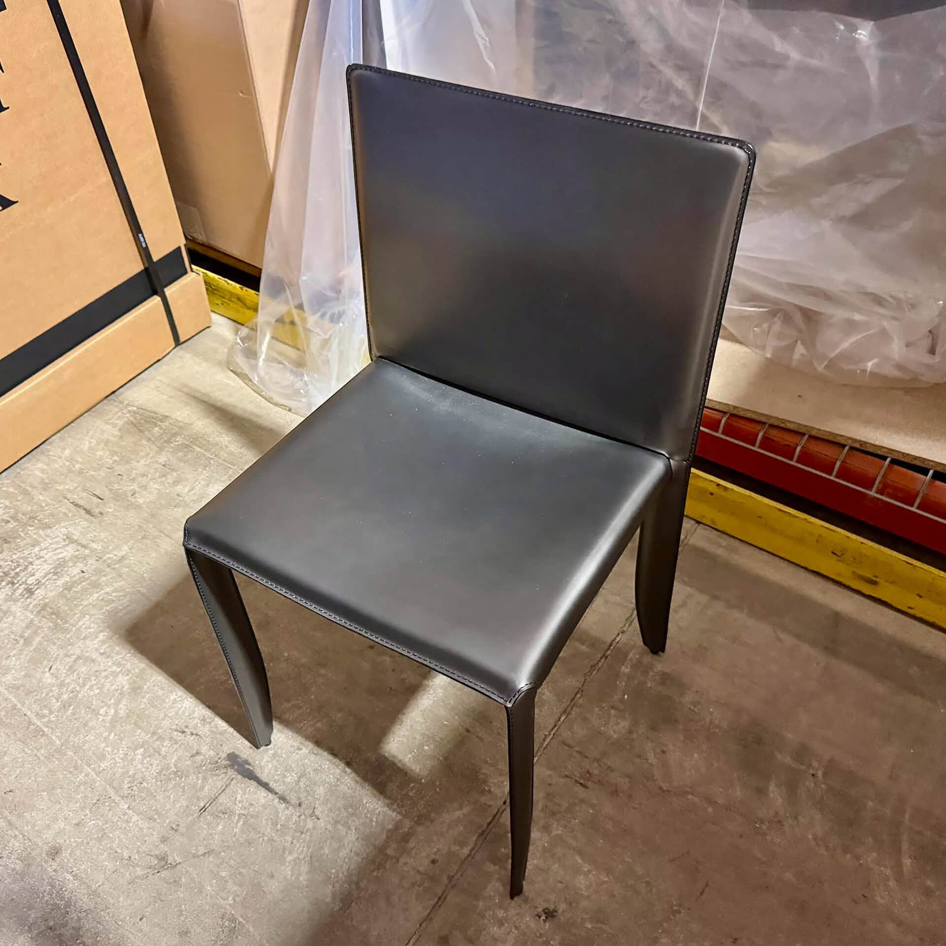 Black upholstered dining chair with sleek wooden legs.