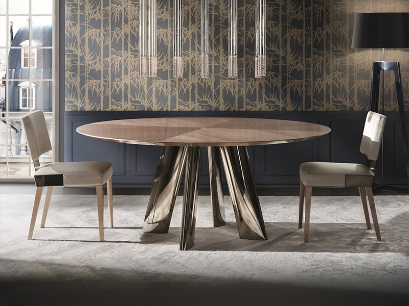 Elegant round dining table with a distinctive metallic base in a stylish dining room.