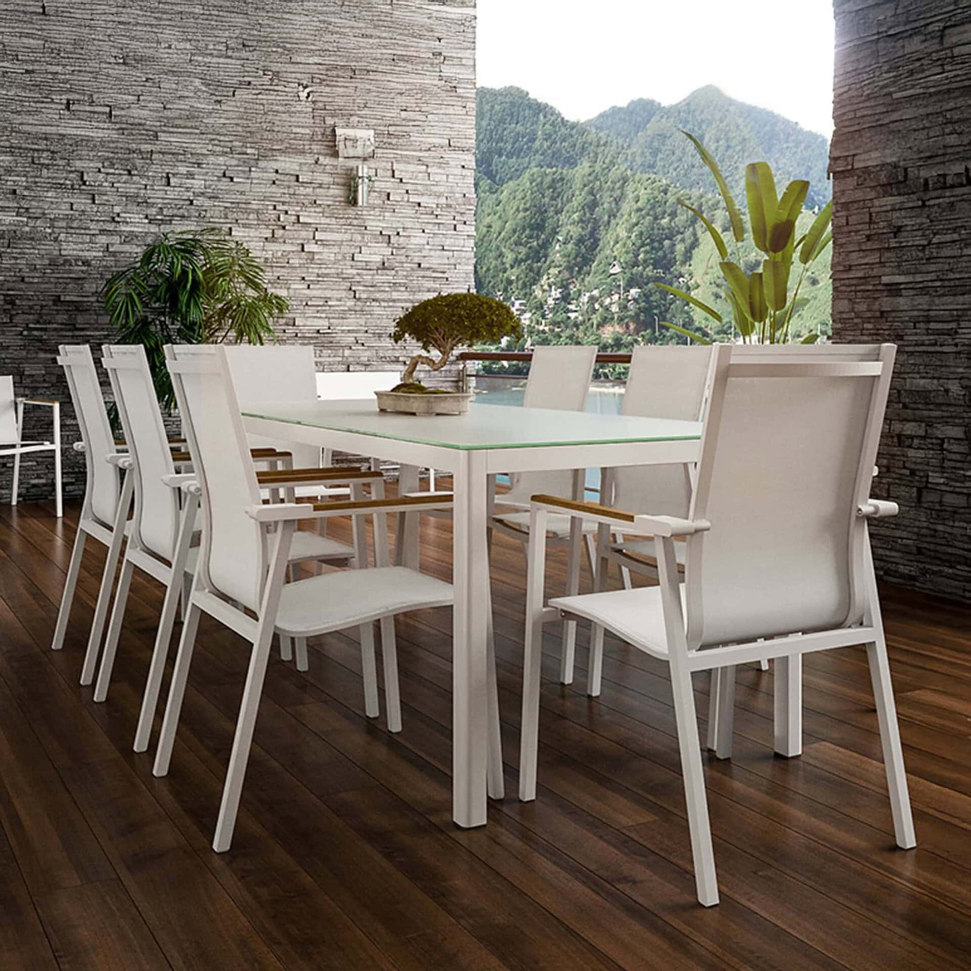 Modern white dining table with chairs in stylish indoor space with mountain view.