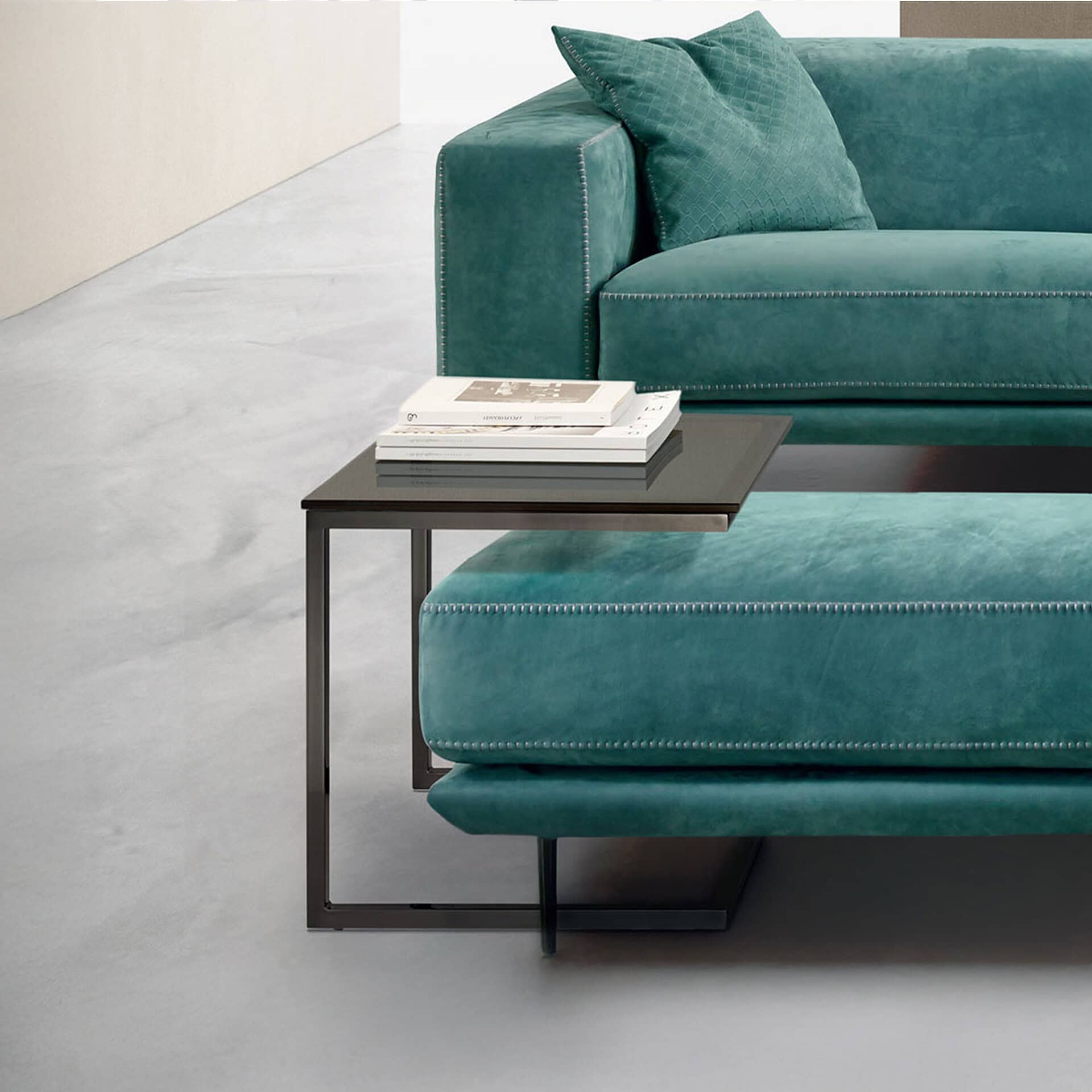 Contemporary teal sofa with matching cushions and sleek side table.