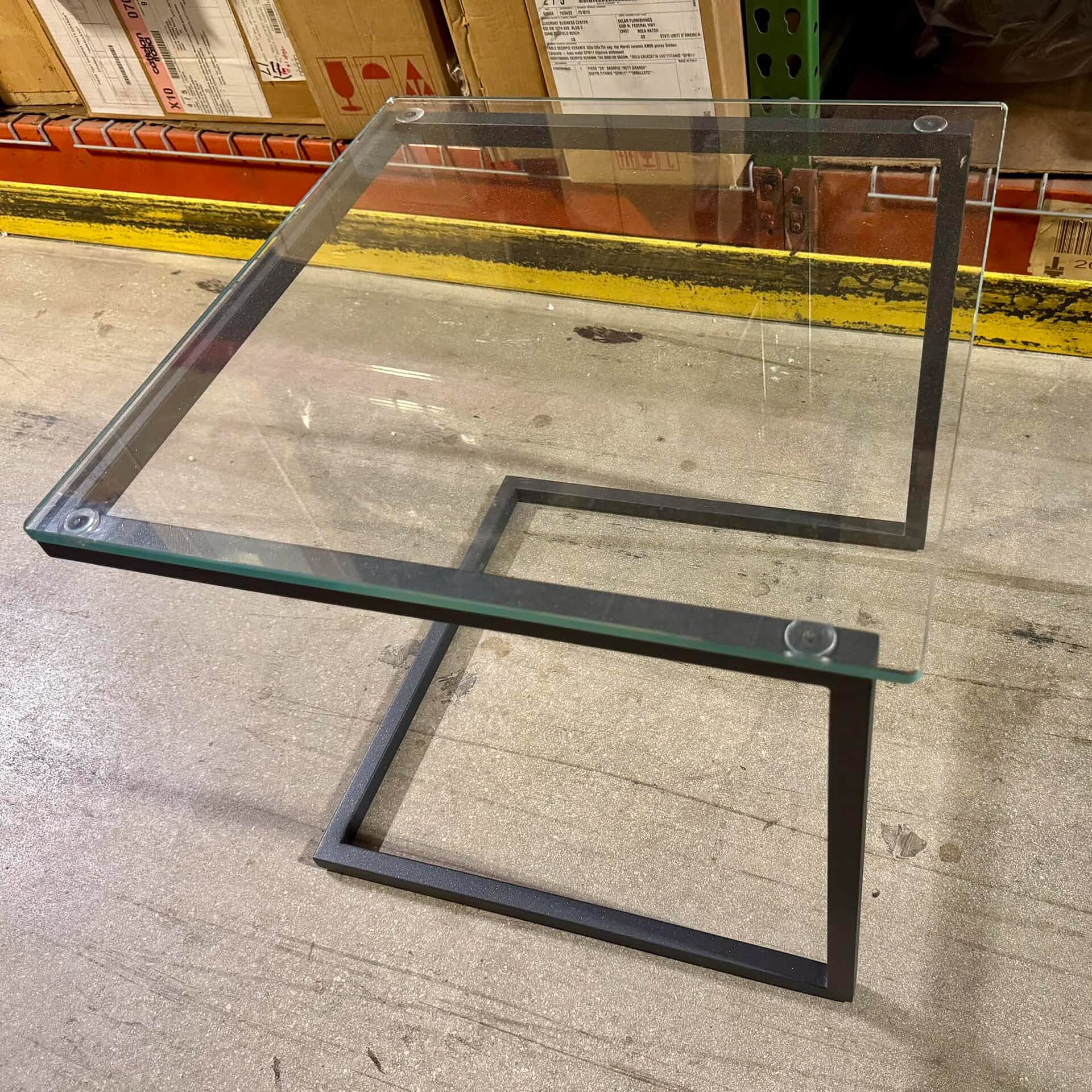 Modern glass and metal side table for living room or office decor.
