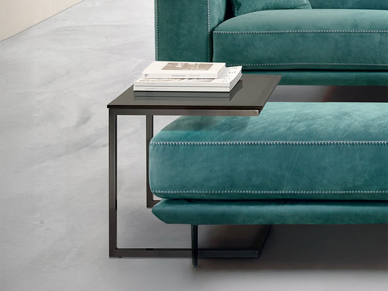 Teal velvet sofa with black metal side table in contemporary living room.