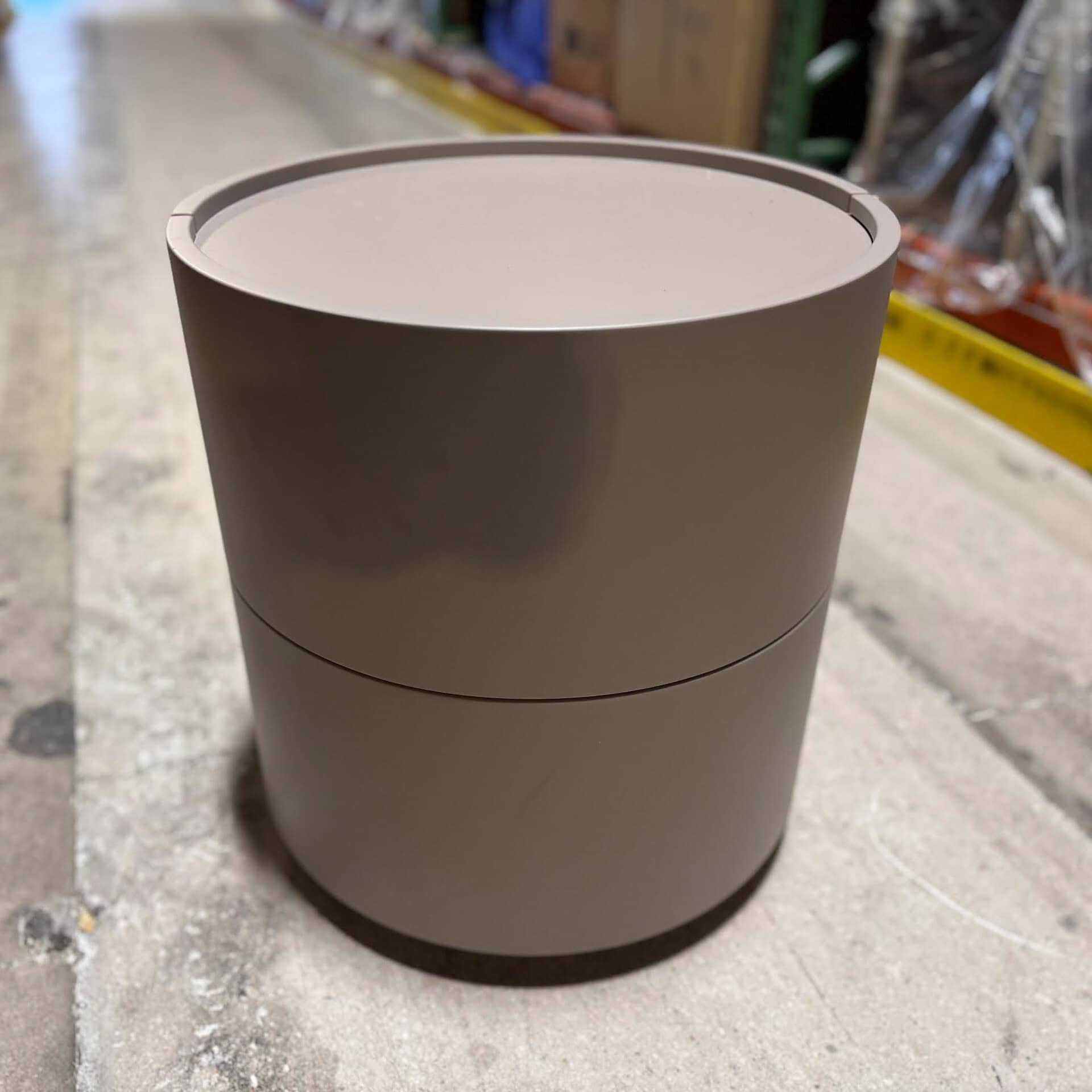 Contemporary round nightstand with sleek design and storage compartment.