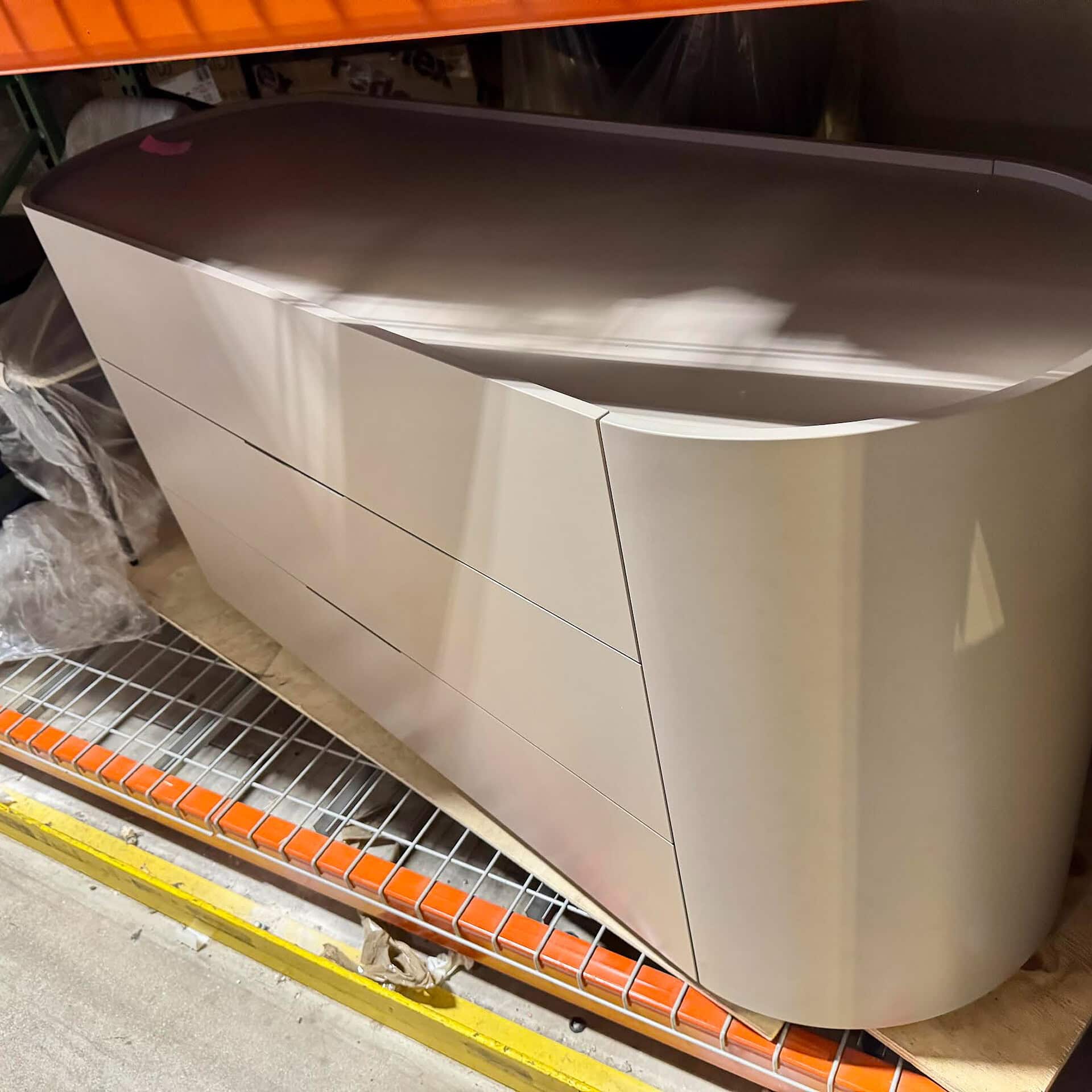 Contemporary white dresser with smooth curved design for bedroom storage.
