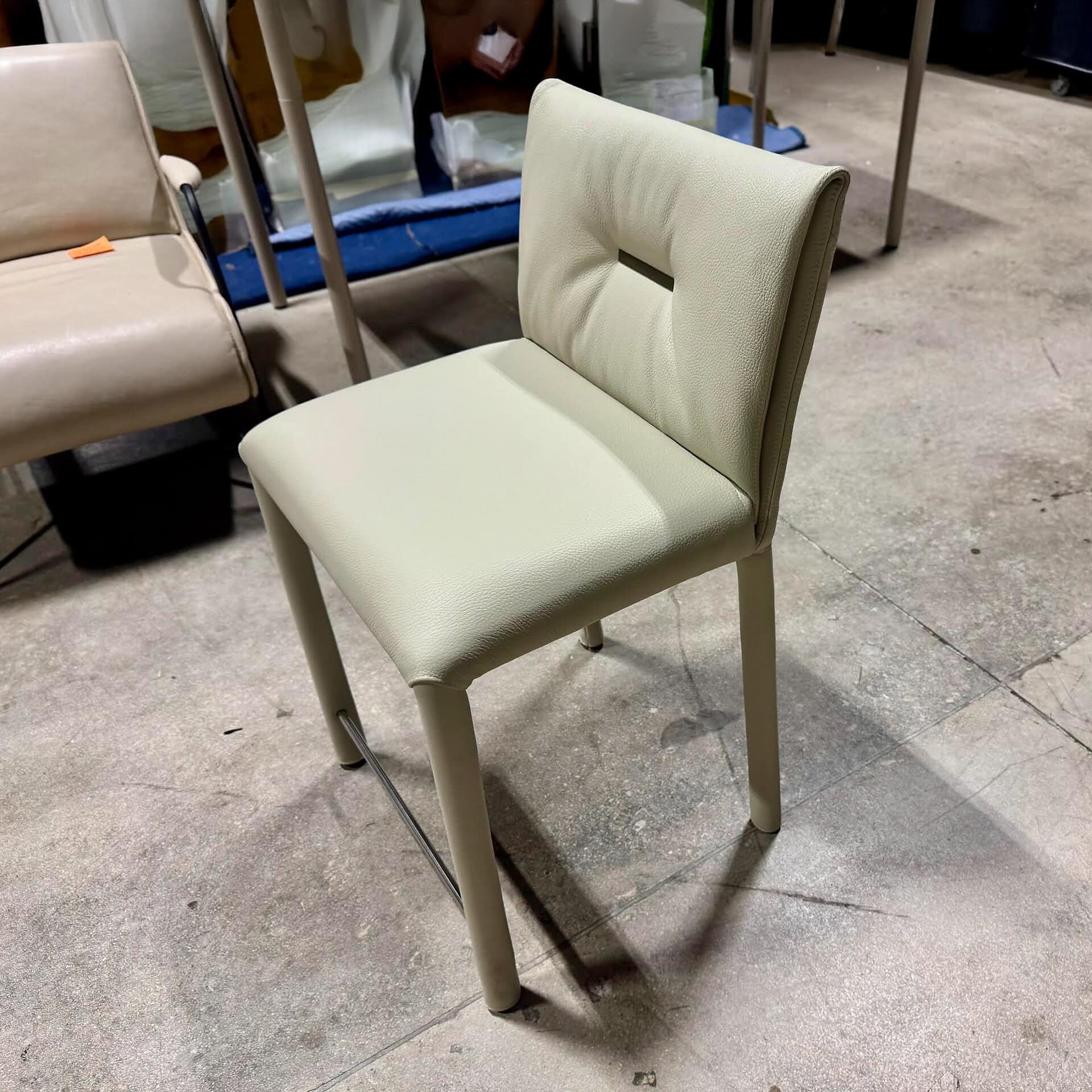 Elegant cream upholstered dining chair with a stylish cutout backrest.