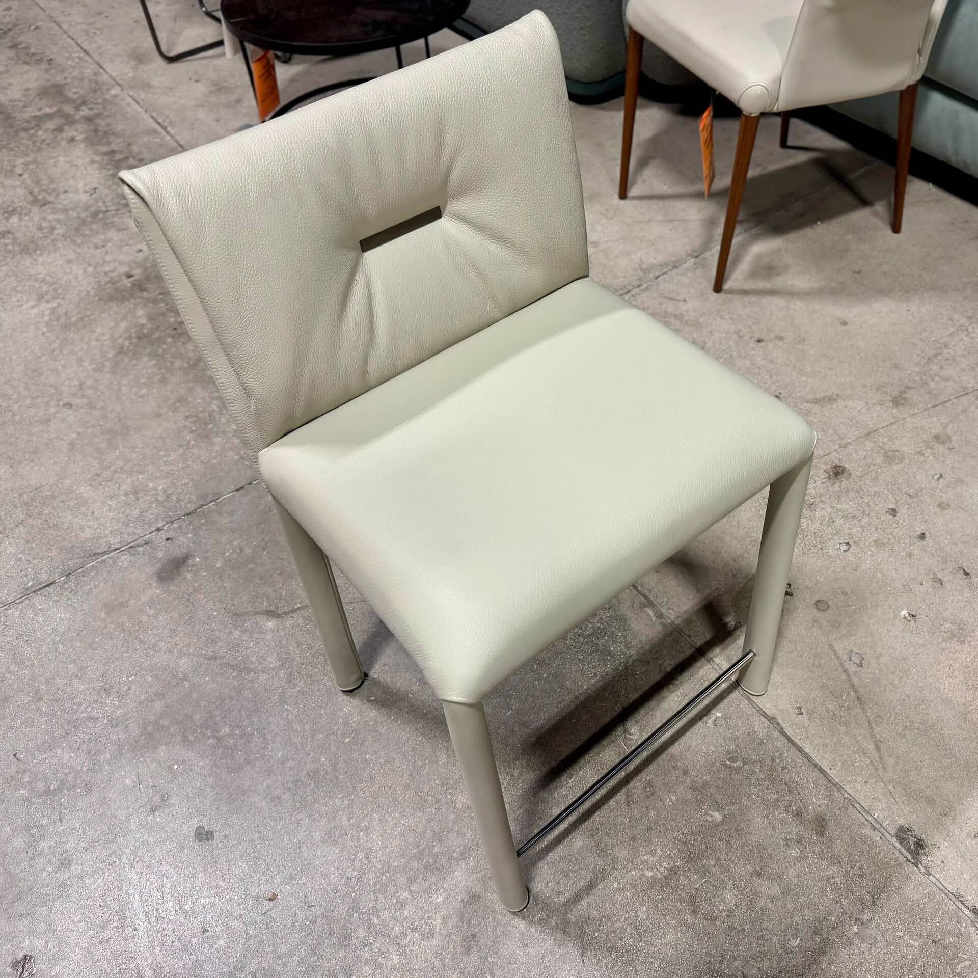 White upholstered dining chair with a stylish cutout backrest.