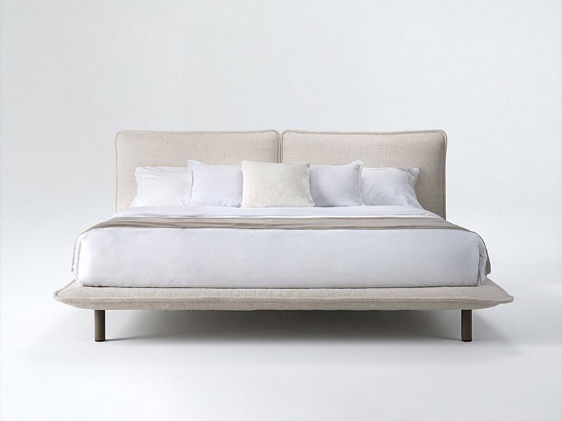 Elegant beige upholstered bed frame with plush pillows and clean design.