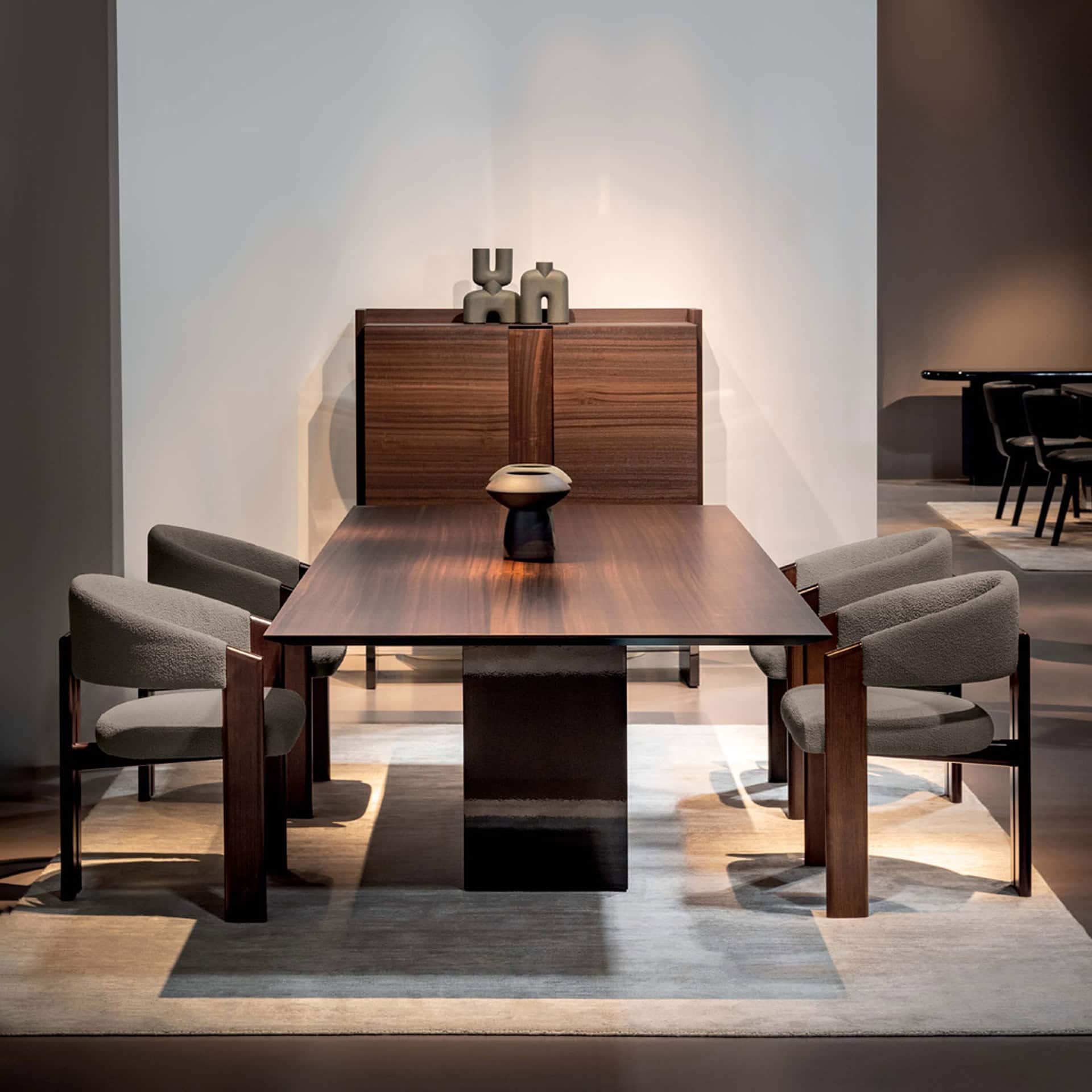 Elegant walnut dining table with six chairs and decorative accents in a contemporary setting.