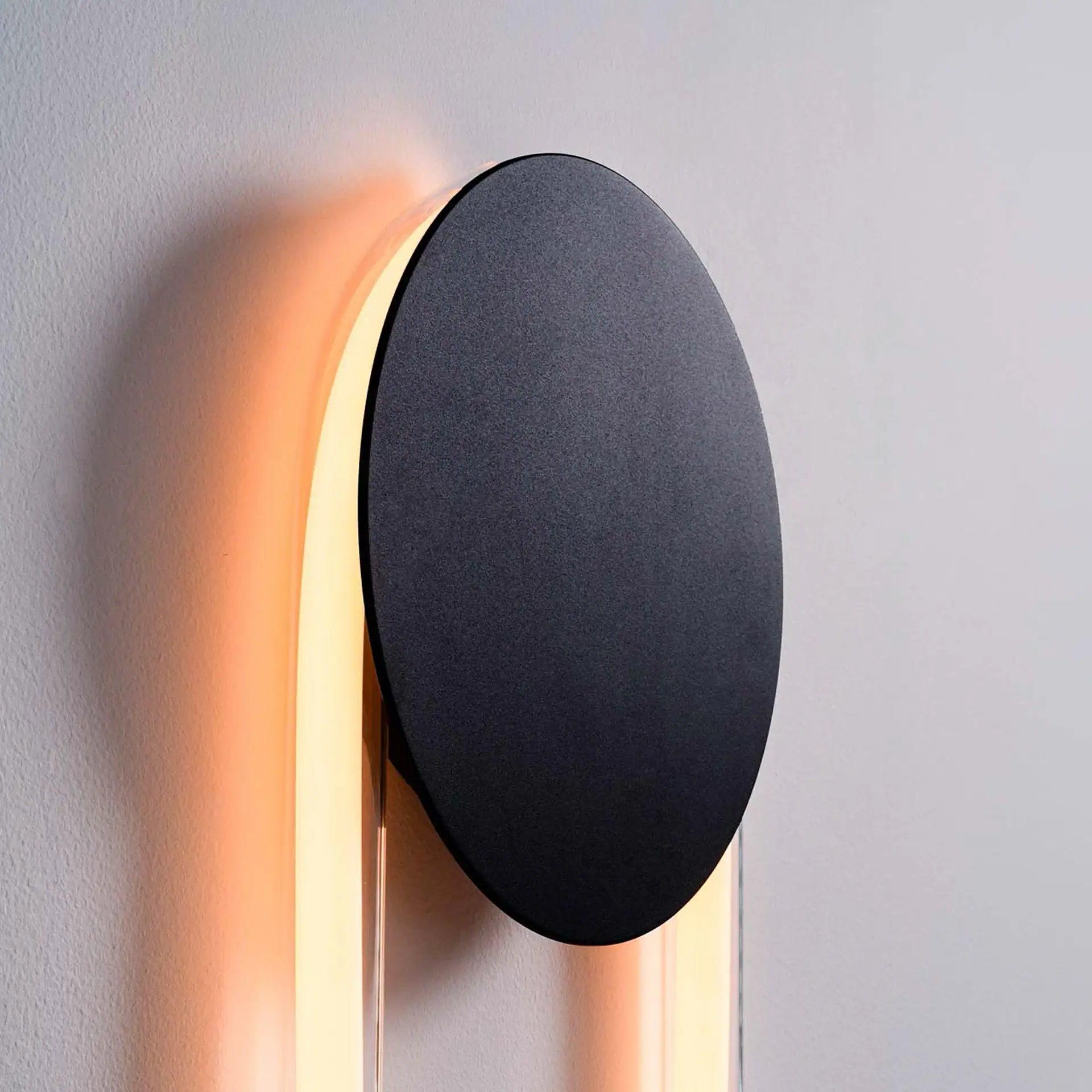 Sklar Furnishings RA Sculptural Wall Sconce on wall with warm glow.