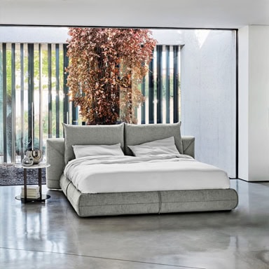 Elegant gray upholstered bed with plush headboard and white bedding.