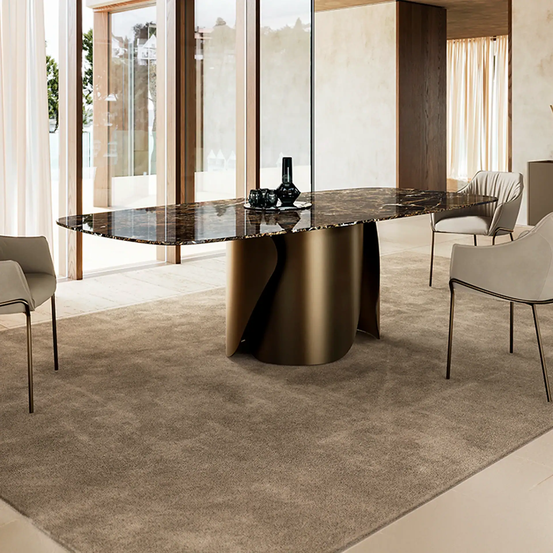 A modern dining room featuring an oval dark brown marble table with a bronze sculptural base, surrounded by four light beige upholstered chairs on a taupe rug. Large windows with wooden frames are in the background.