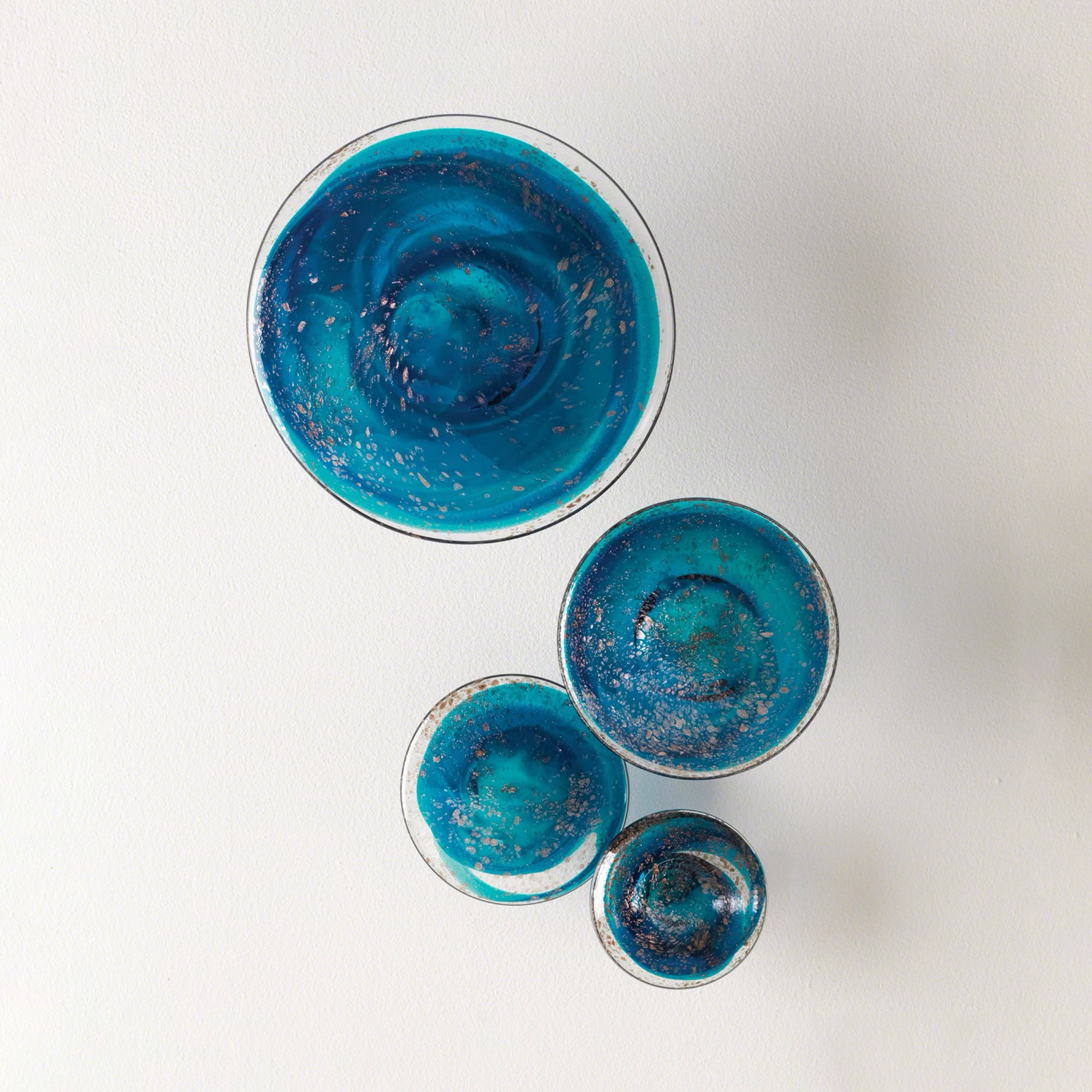 Blue glass art wall decor with swirling patterns and gold accents.