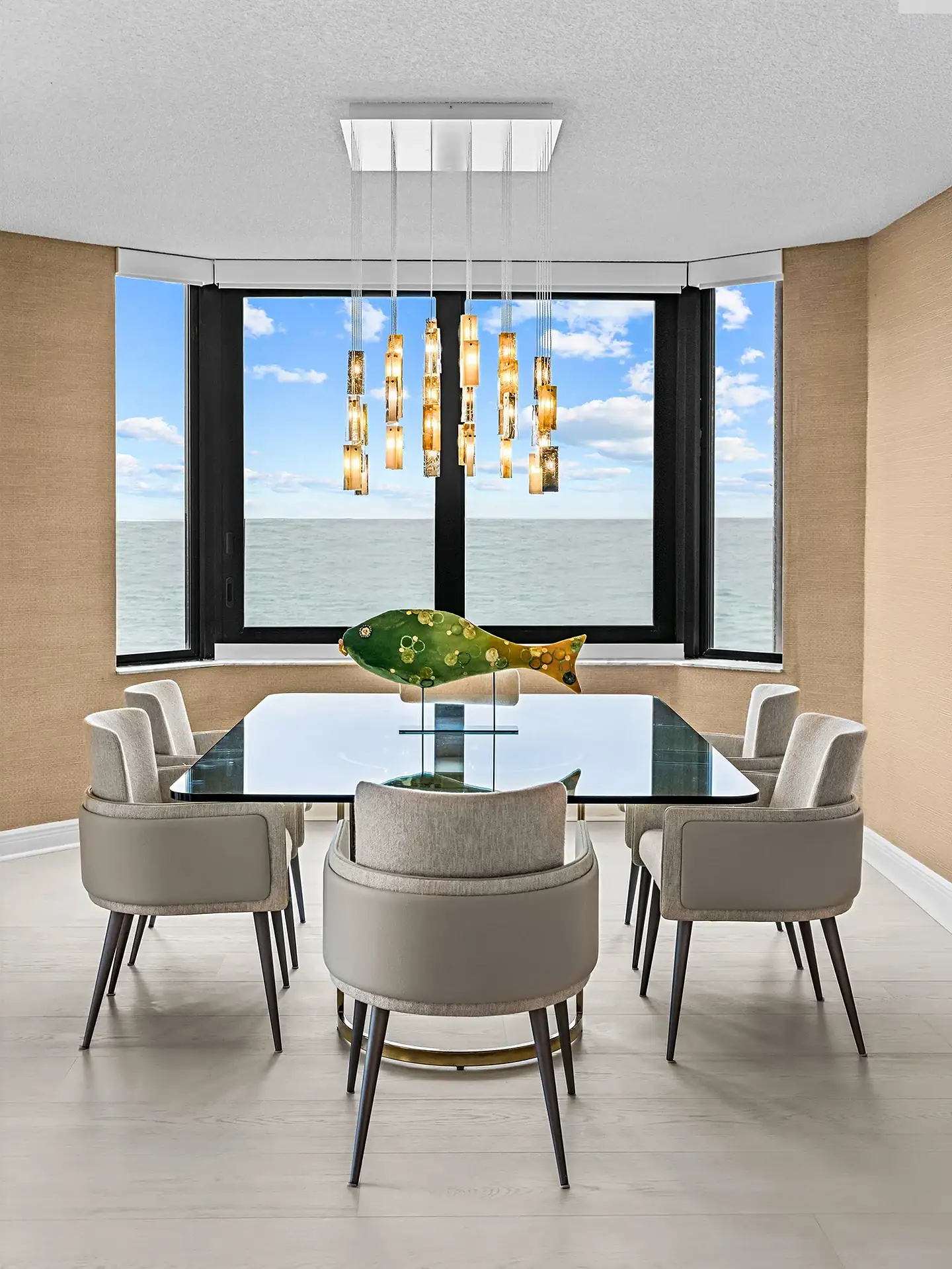 Elegant ocean-view dining room with modern furniture and stylish pendant lighting.