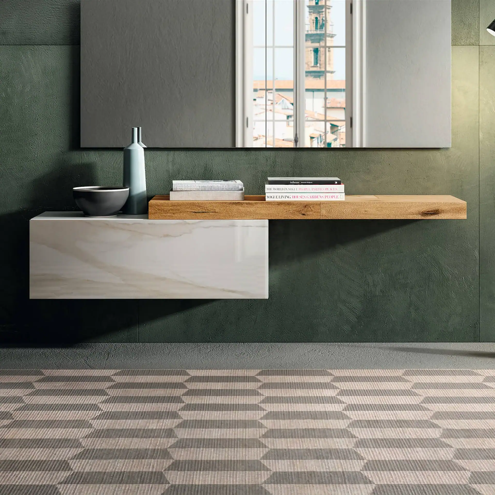 A modern vanity with a wooden shelf and marble-patterned drawer, a large mirror reflecting a window view, against a textured dark green wall and a geometric patterned floor.