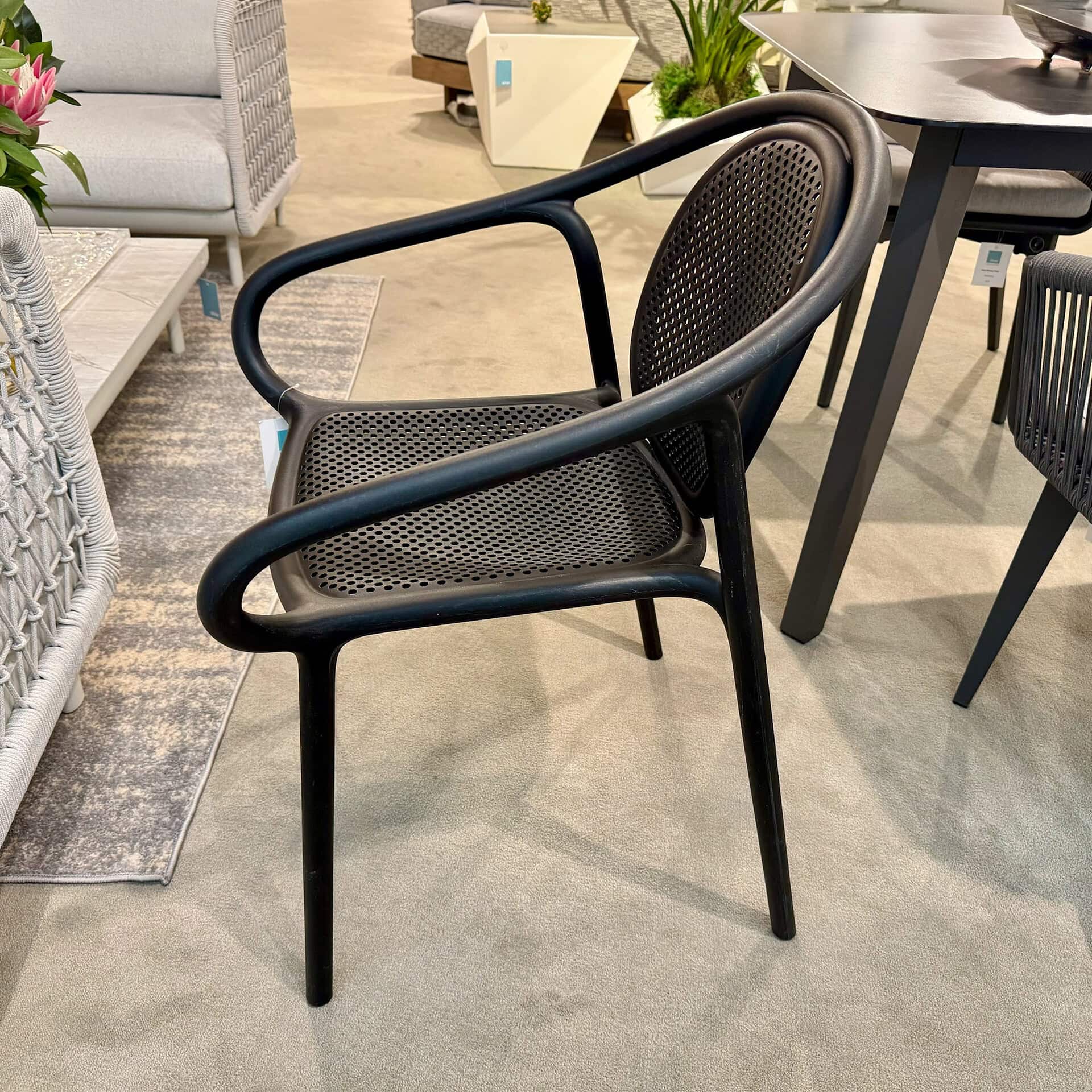Sculptural armchair with black frame and woven seat, ideal for modern interior design.