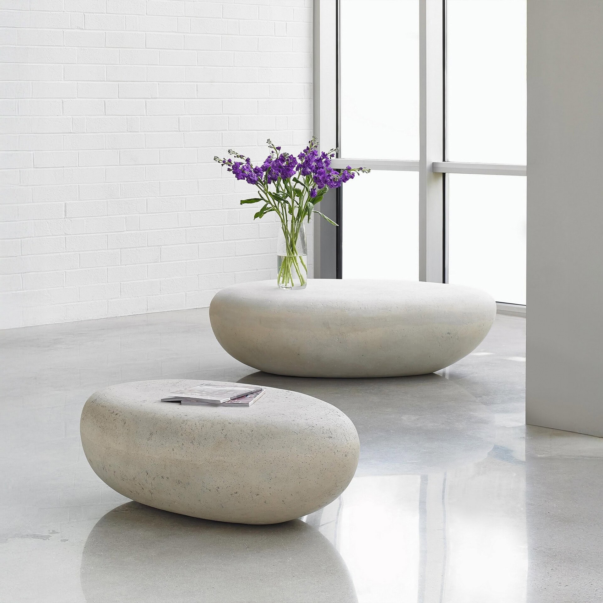 Elegant stone coffee tables with fresh purple flowers in a bright, airy room.