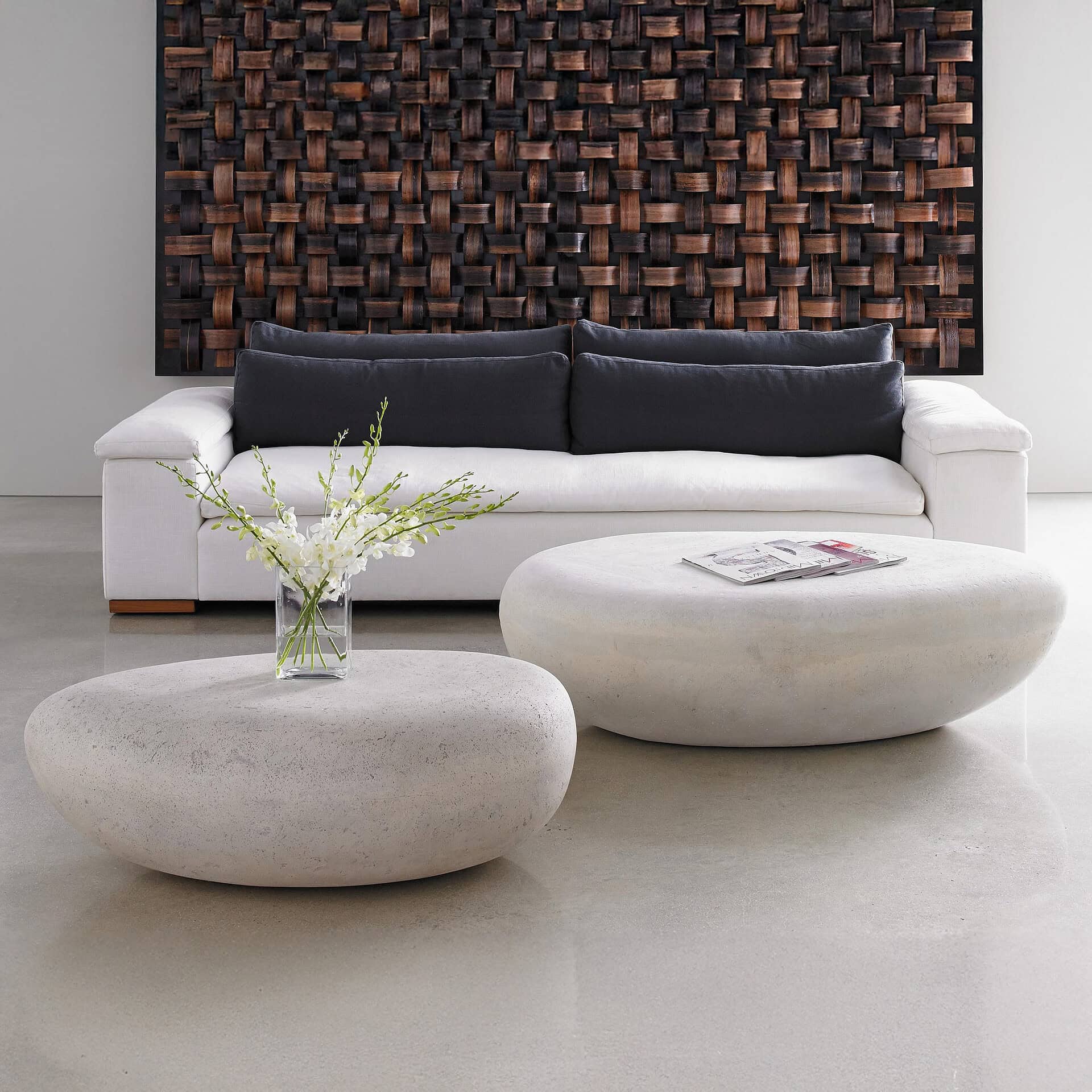 Contemporary living room with white sofa and unique stone coffee tables.