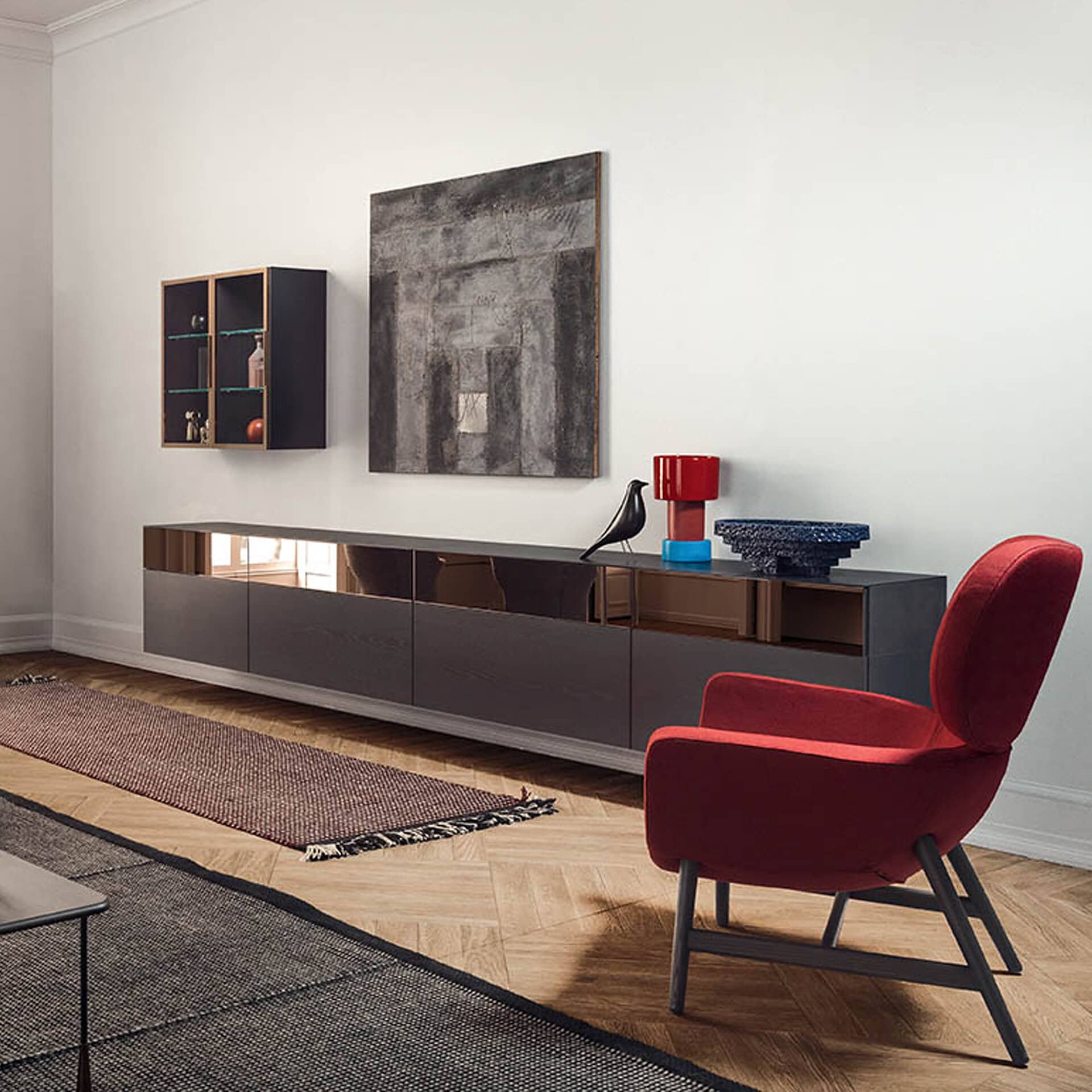 Contemporary living room featuring a glossy black console, abstract artwork, and a plush red armchai.