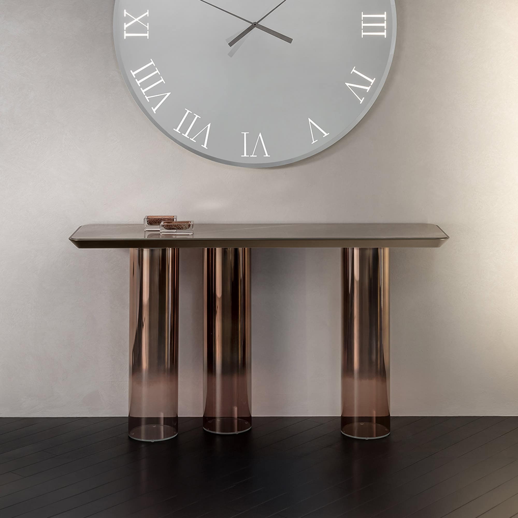 Elegant glass console table with three cylindrical legs and a sleek surface.