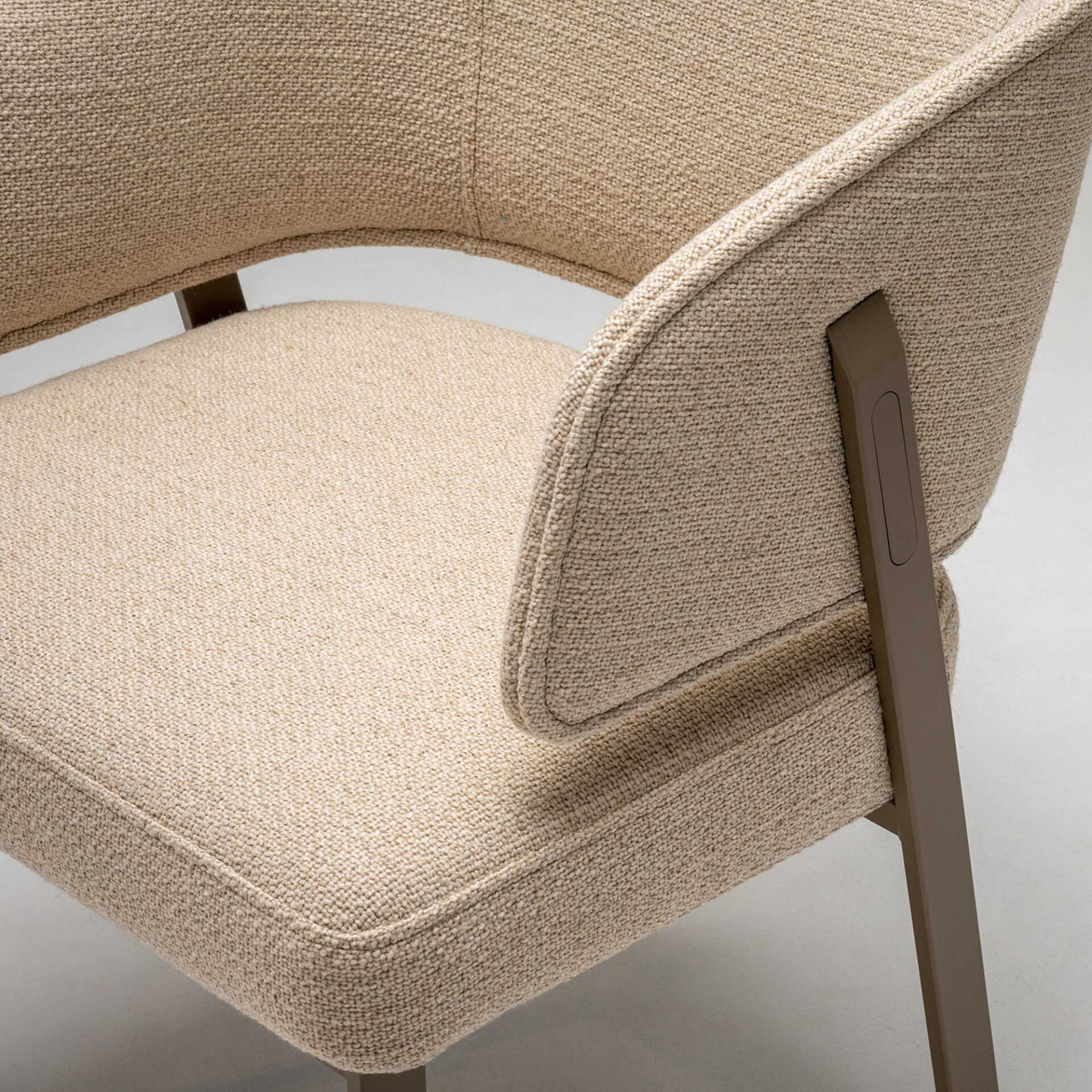 Elegant beige upholstered armchair with sleek metal legs.