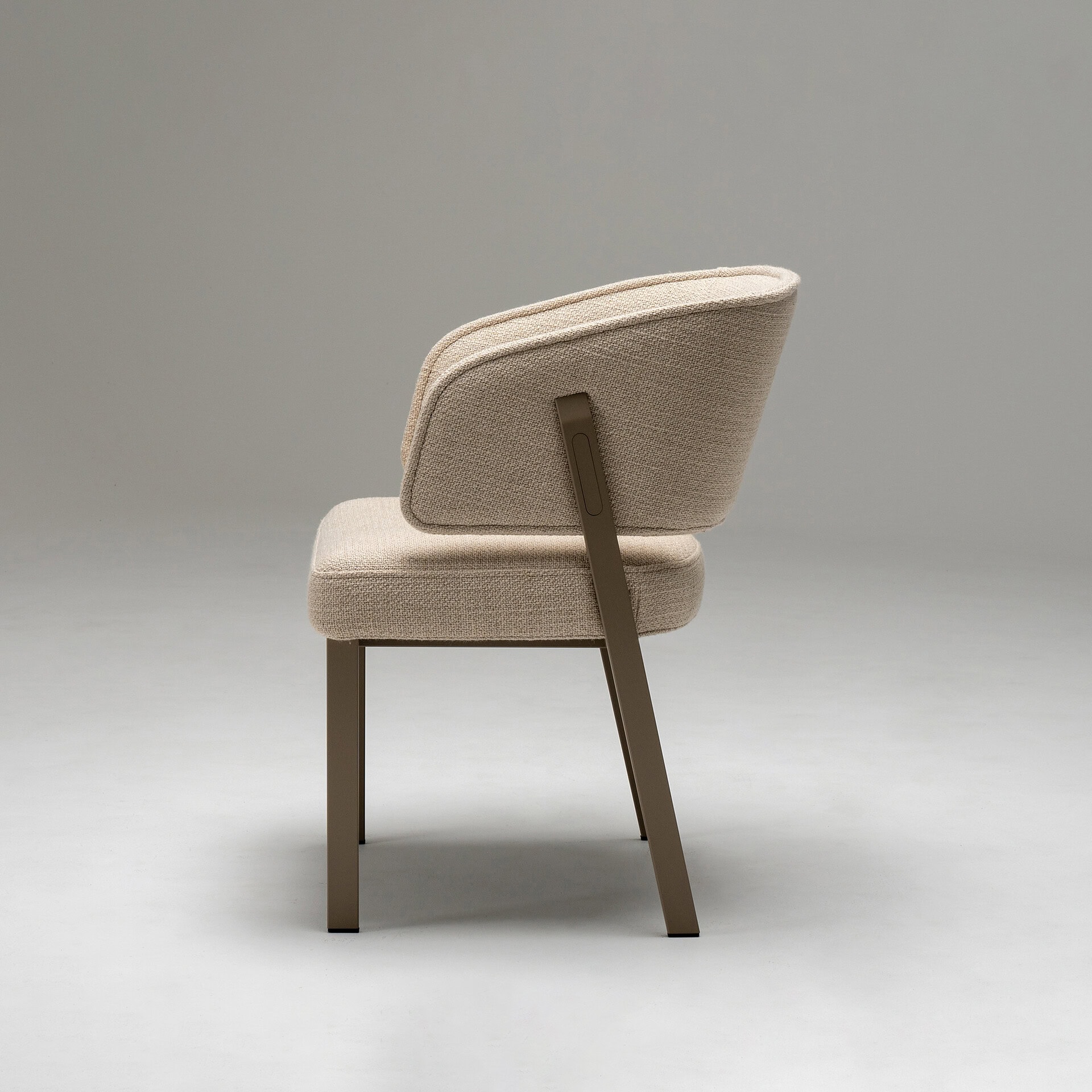 Beige upholstered accent chair with wooden legs, perfect for contemporary living spaces.