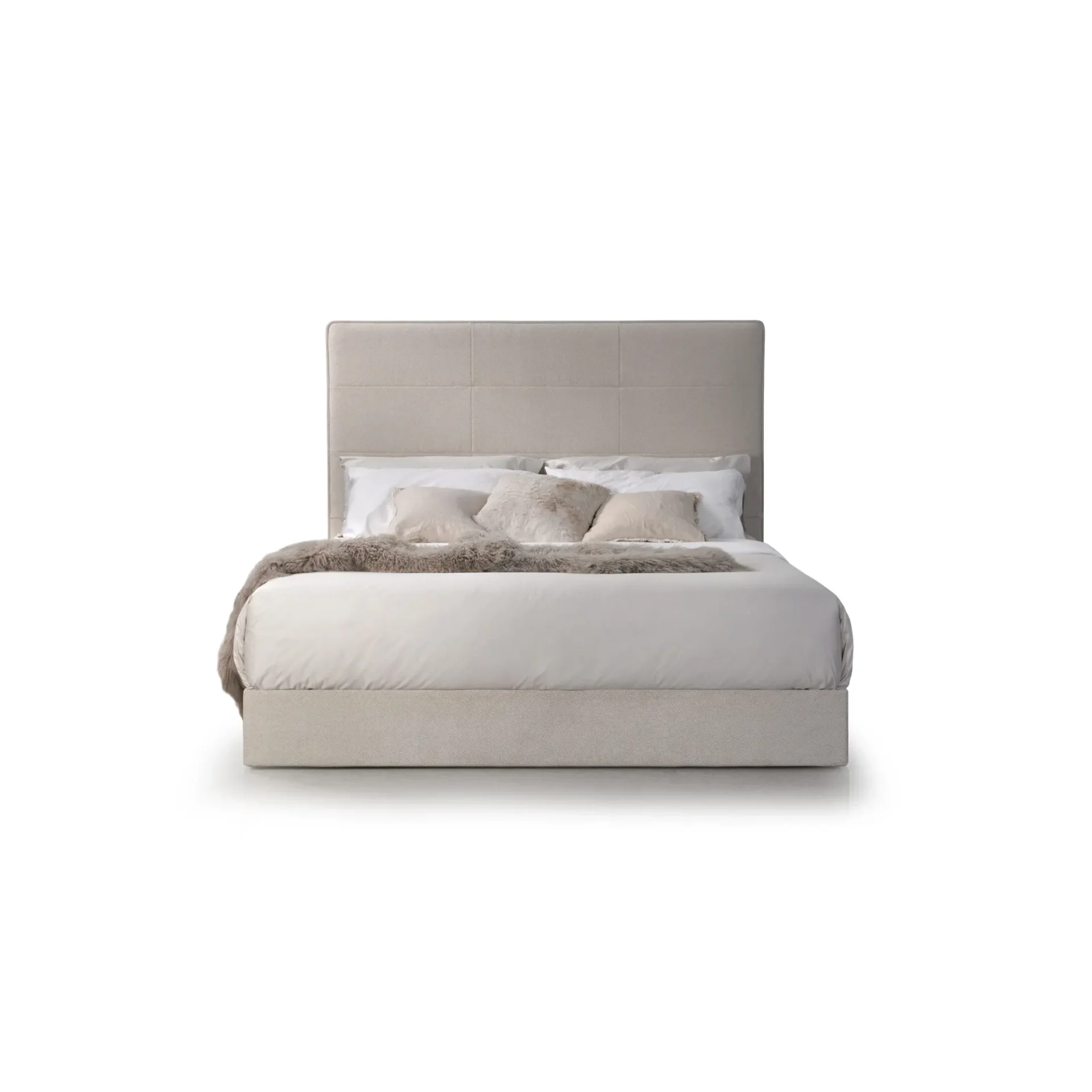 A modern upholstered bed with a light beige tufted headboard, white bedding, and three decorative pillows including a shaggy faux fur one, against a white background.