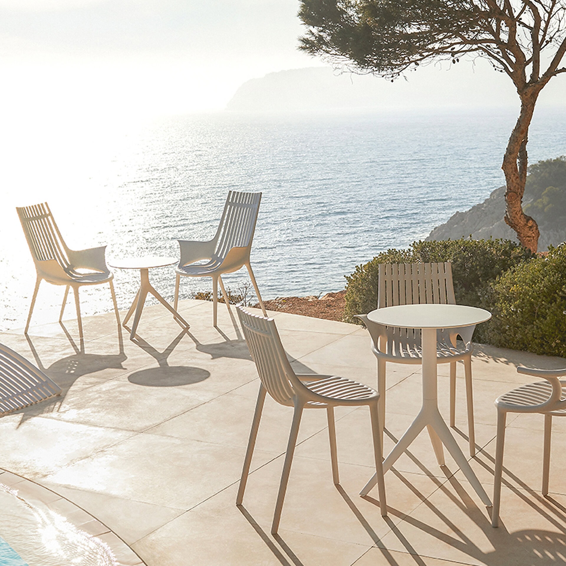 Outdoor patio furniture set with ocean view and scenic landscape.