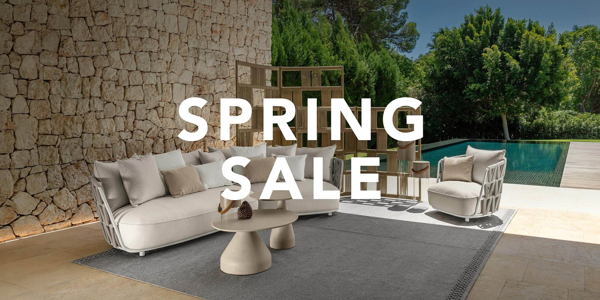 Outdoor furniture set with sofa, armchairs, and coffee table by the poolside.