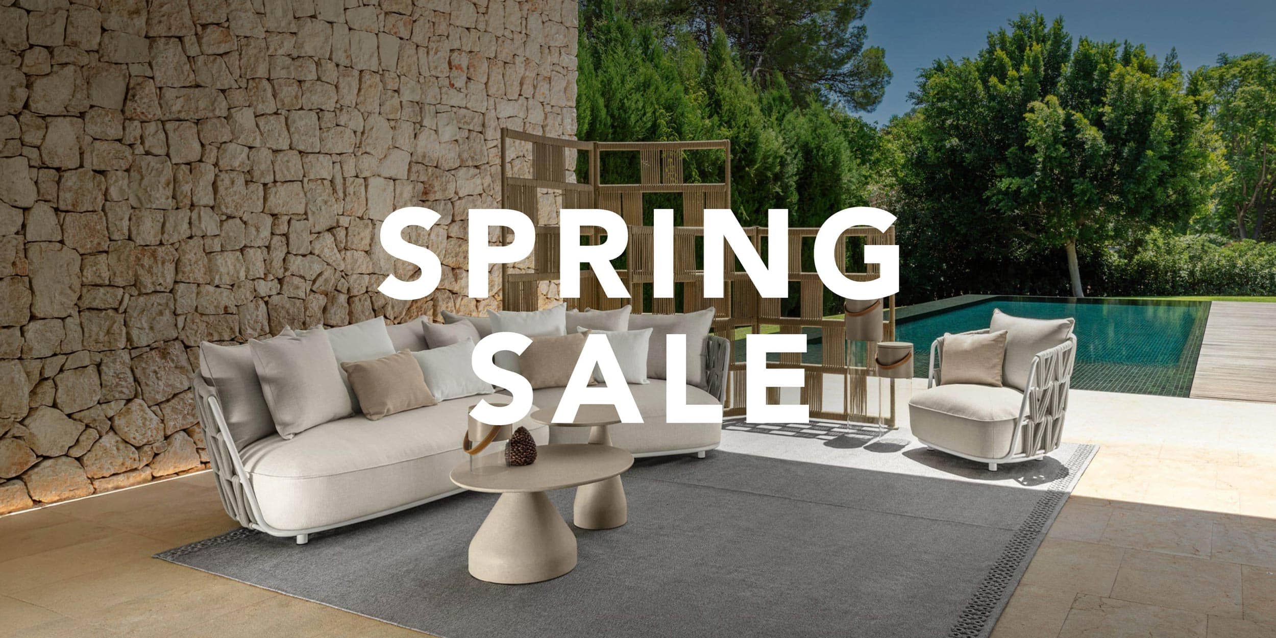 Elegant outdoor sofa set with armchairs and coffee table by the pool.