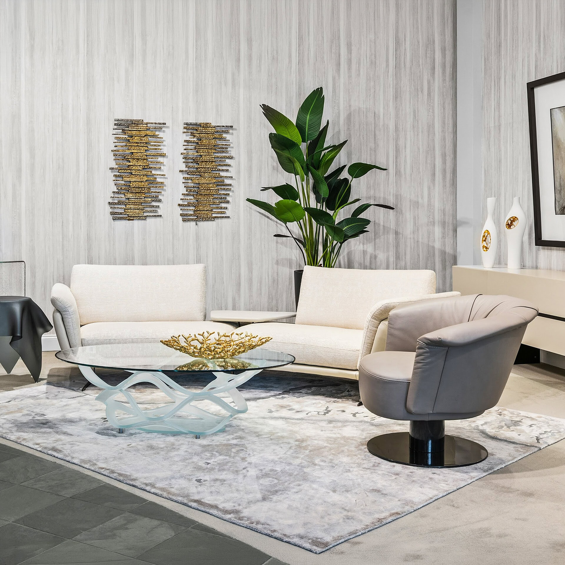 Elegant modern living room with stylish sofas, armchair, and decorative accents.