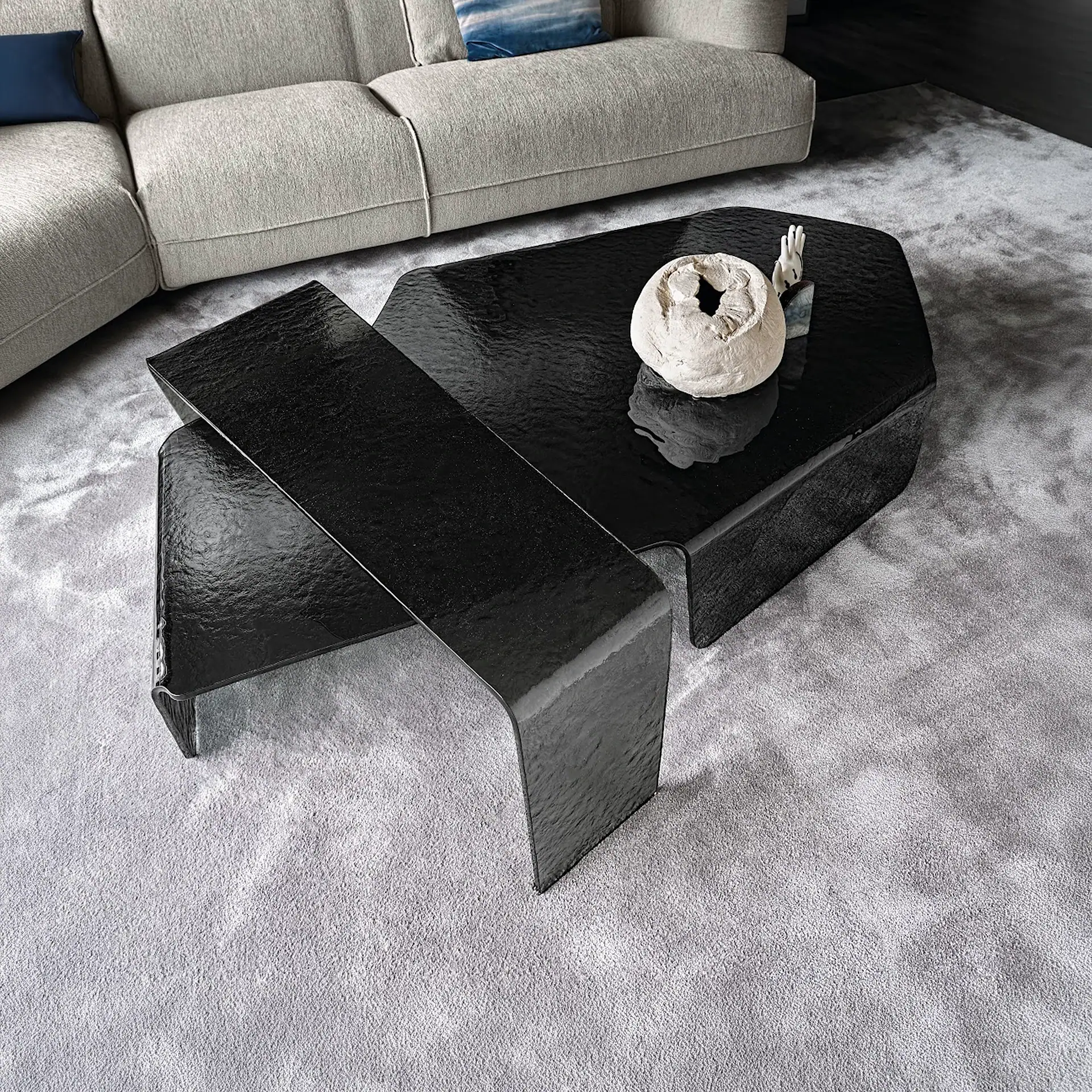 Chimera hammered glass coffee table with decorative sculpture on top.