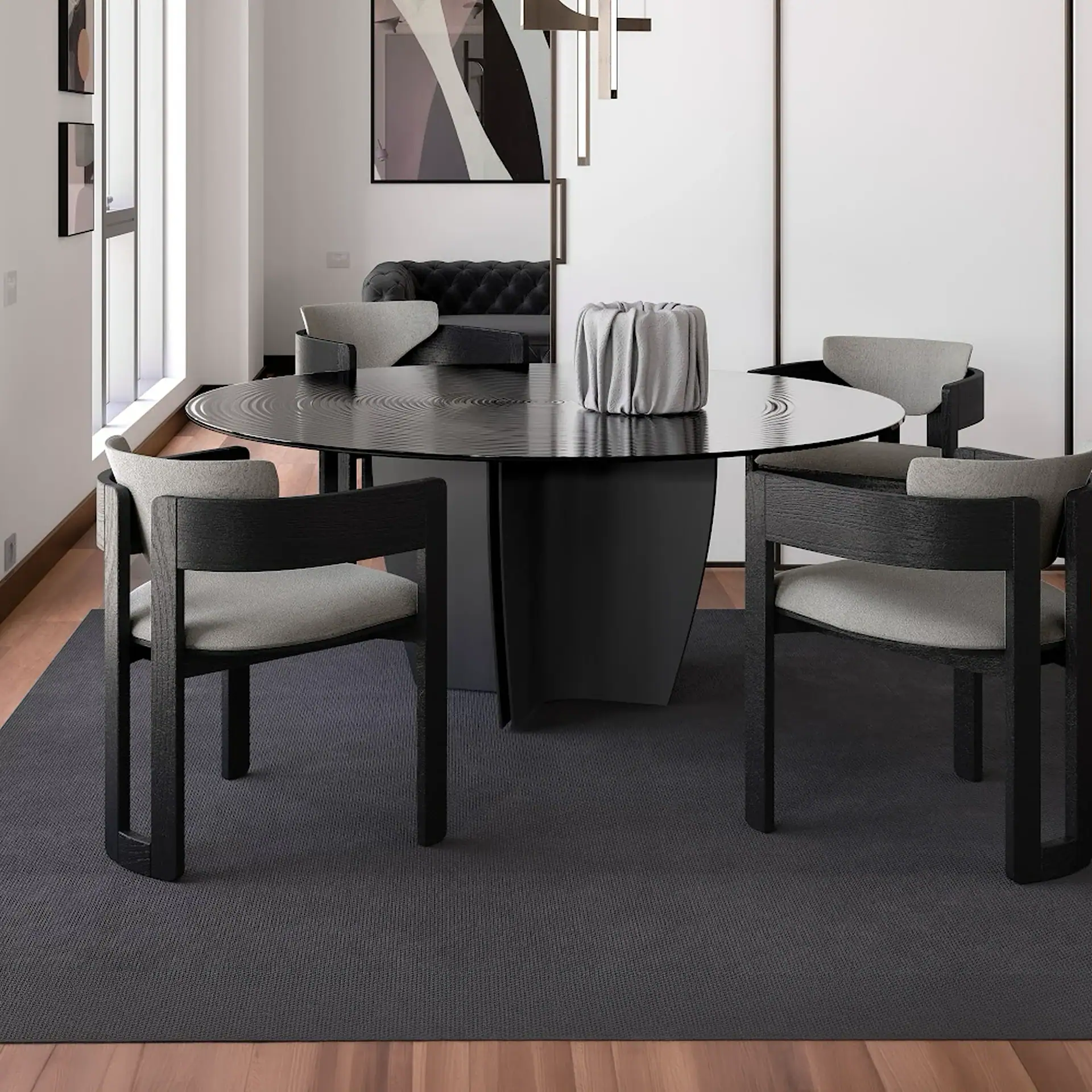 A modern dining room with a black round table, four grey and black chairs, a dark grey rug, and light wooden floors. White walls and a window are in the background.