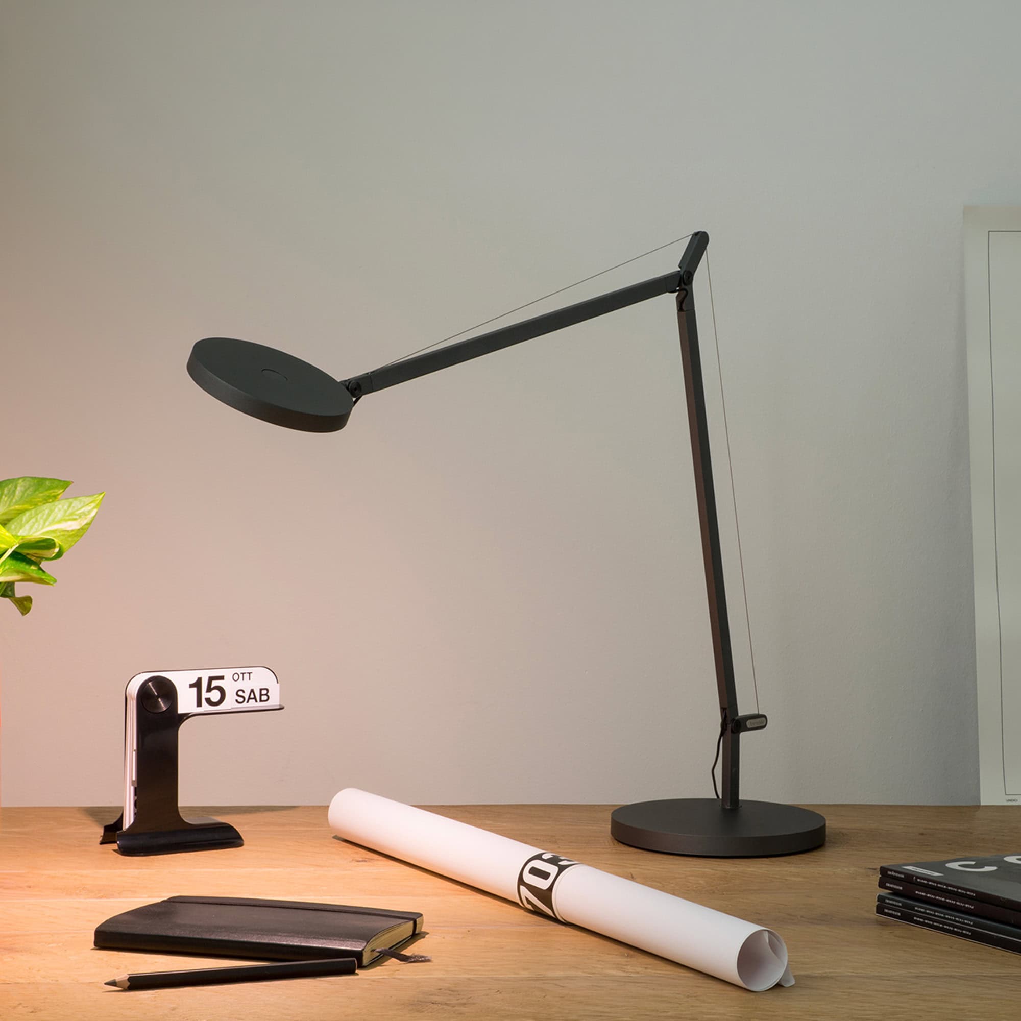 Adjustable black Demetra table lamp for modern home or office lighting. Sleek design with flexible a.