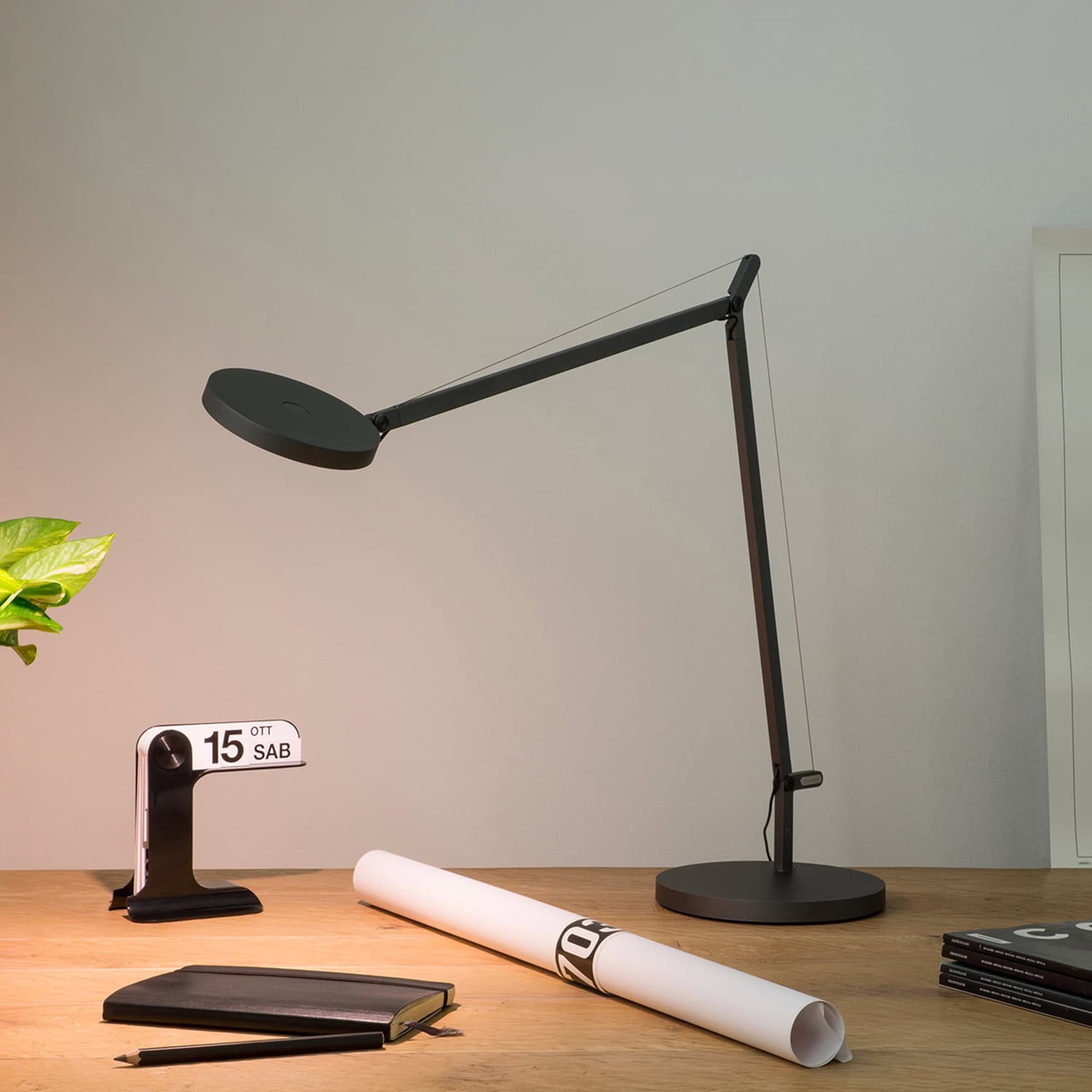 Adjustable black Demetra table lamp for modern home or office lighting. Sleek design with flexible a.